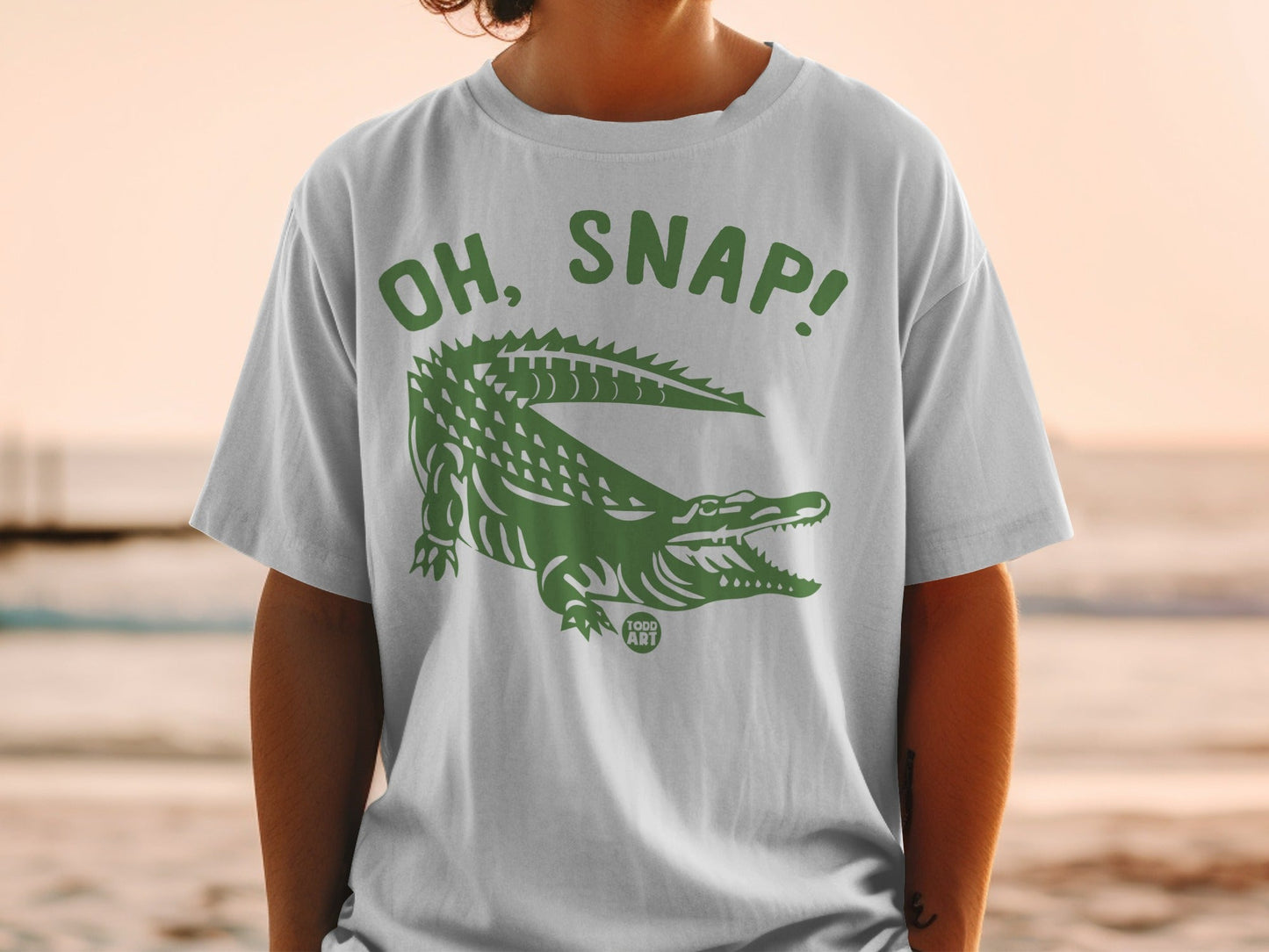 White t-shirt with green alligator graphic and "OH, SNAP!" text.