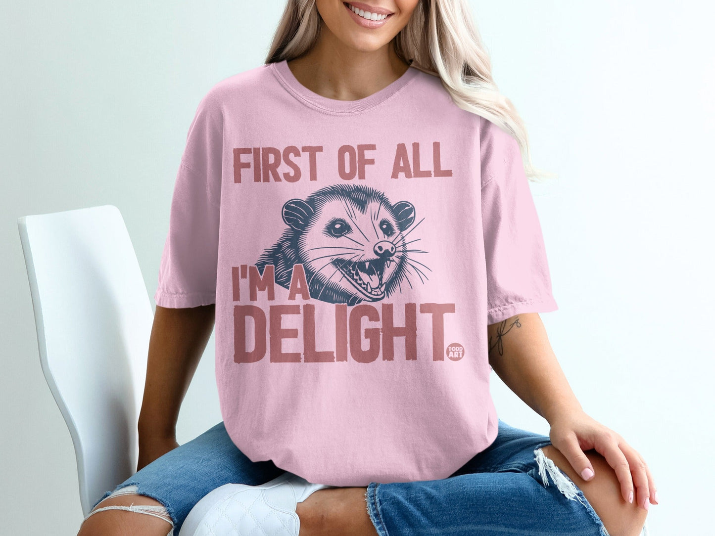 Pink t-shirt with a possum and "First of all I'm a DELIGHT" text.