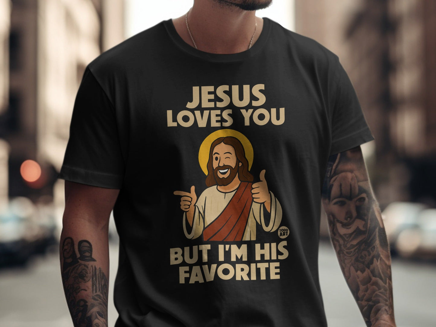 Jesus Loves You But I'm His Favorite t-shirt with cartoon Jesus giving thumbs up.