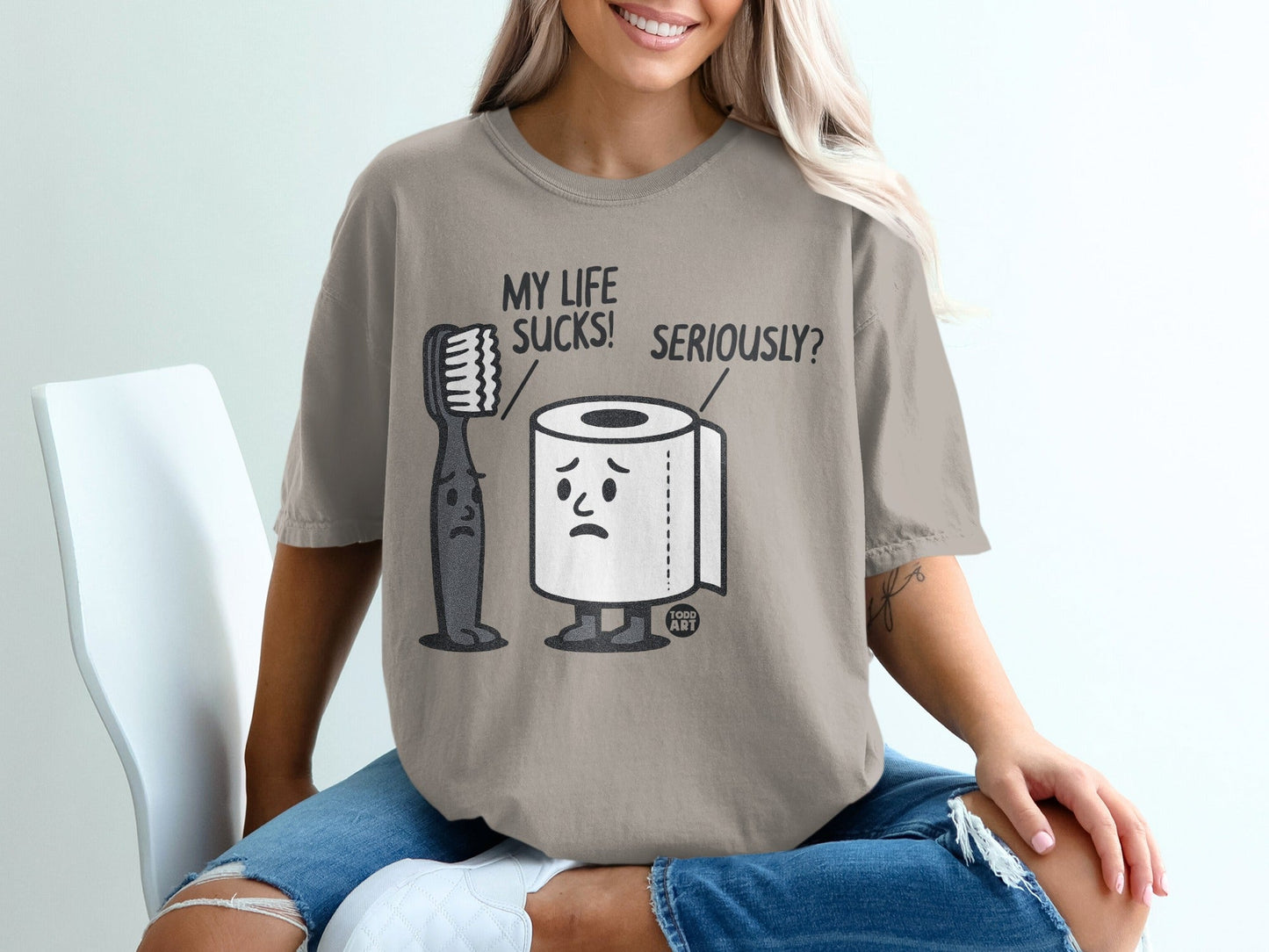 T-shirt with cartoon toothbrush and toilet paper characters saying "My Life Sucks! Seriously?".