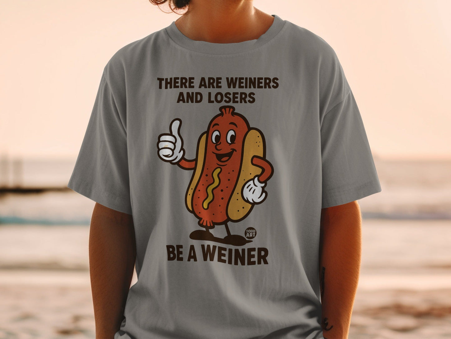 Grey t-shirt with cartoon hot dog giving a thumbs up, saying "THERE ARE WEINERS AND LOSERS BE A WEINER."