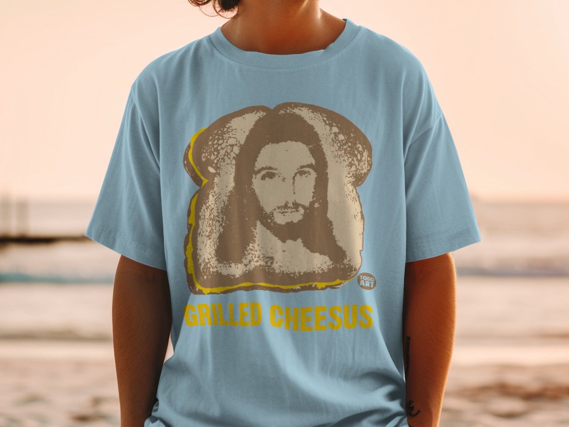 Light blue t-shirt featuring a grilled cheese sandwich with Jesus' face.