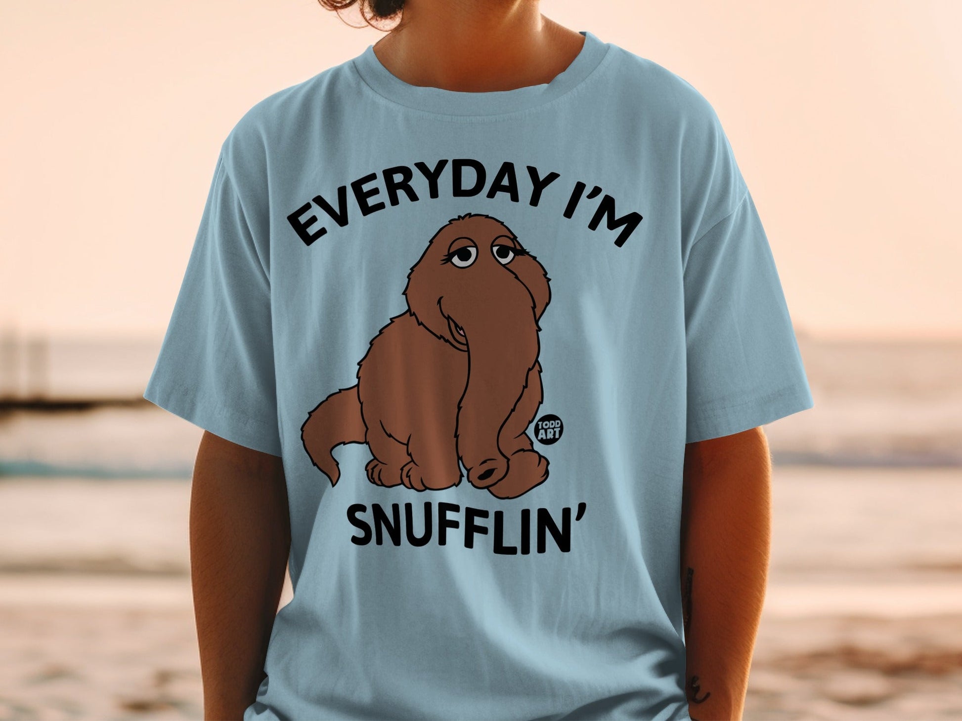 Light blue t-shirt with brown cartoon character and "EVERYDAY I'M SNUFFLIN'" text.