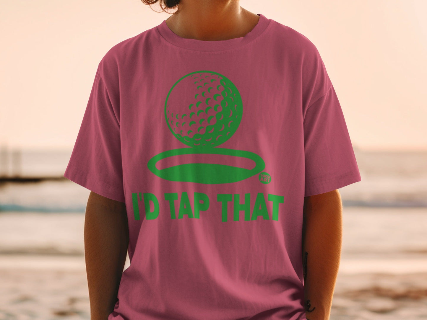 Pink t-shirt with green golf ball logo and "I'D TAP THAT" text.