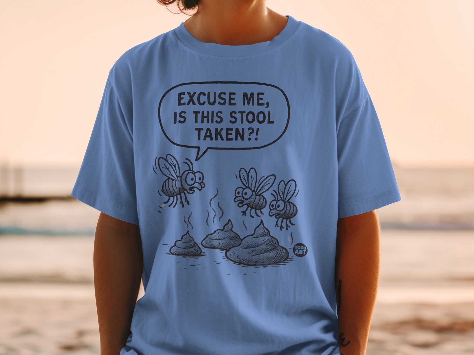 Blue t-shirt with cartoon flies and poop graphic and text "Excuse me, is this stool taken?!".
