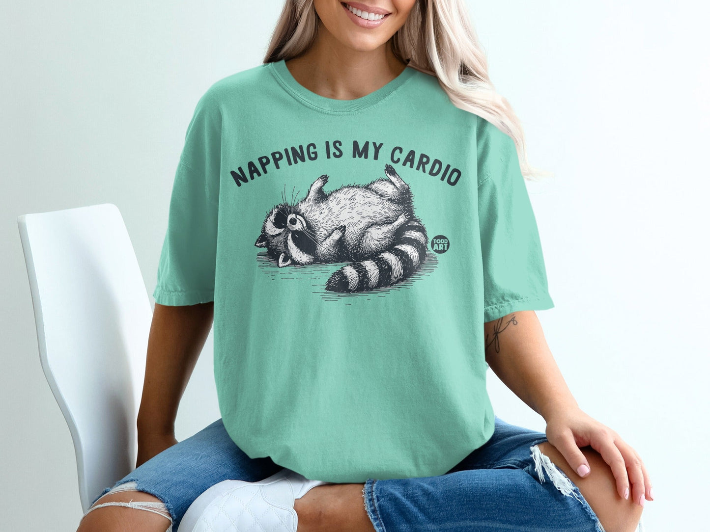 T-shirt with raccoon design and text "Napping is my cardio".