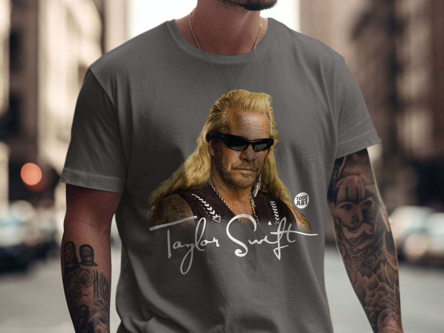 Dog the Bounty Hunter wearing a gray t-shirt with his portrait and signature.