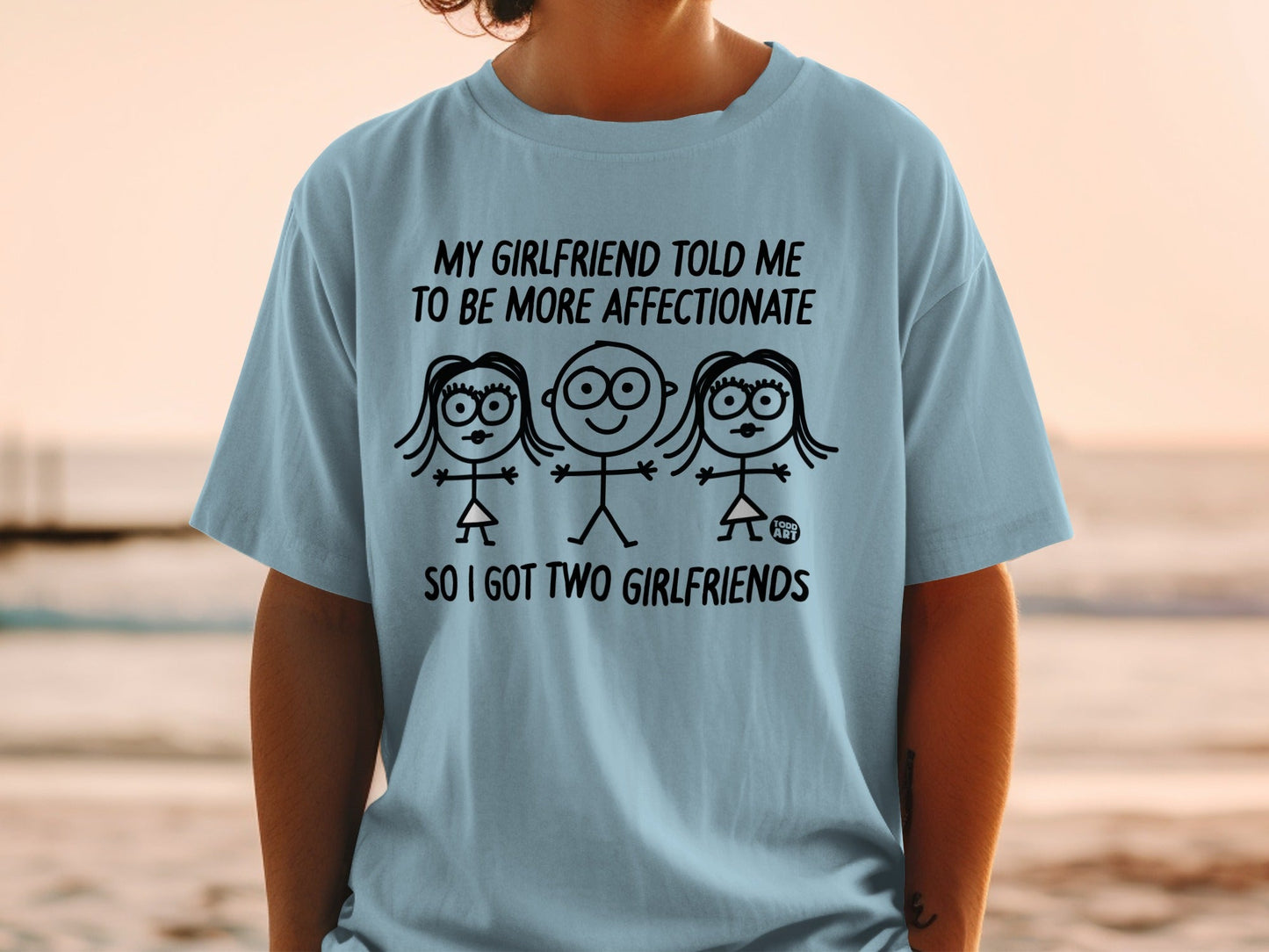 Light blue t-shirt with three stick figures and text about having two girlfriends.