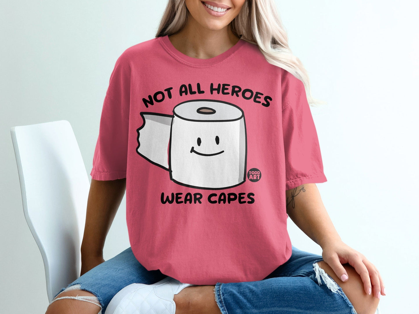 Pink t-shirt with cartoon toilet paper and "Not All Heroes Wear Capes" text.