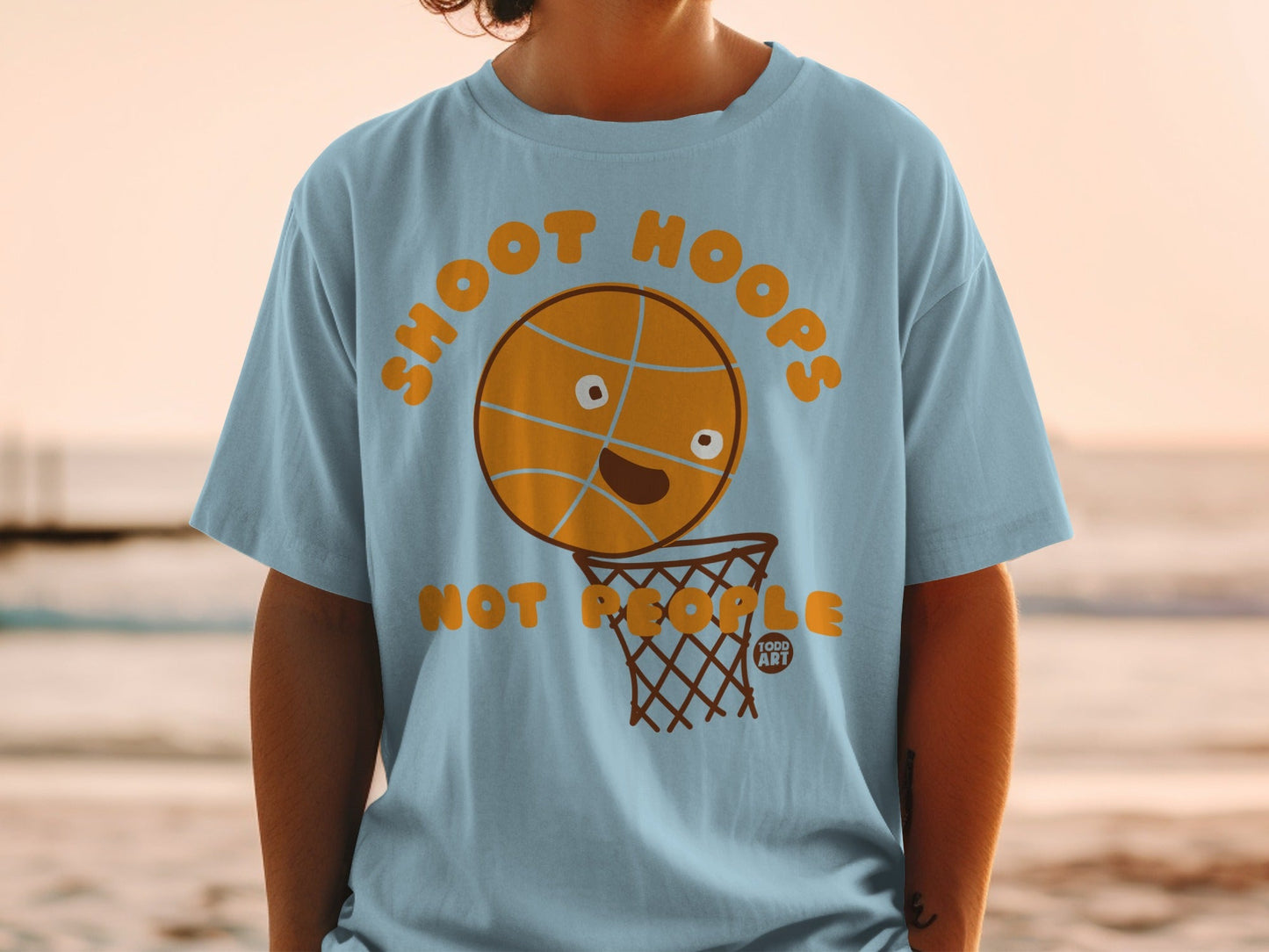 Light blue t-shirt with cartoon basketball and hoop saying "SHOOT HOOPS".