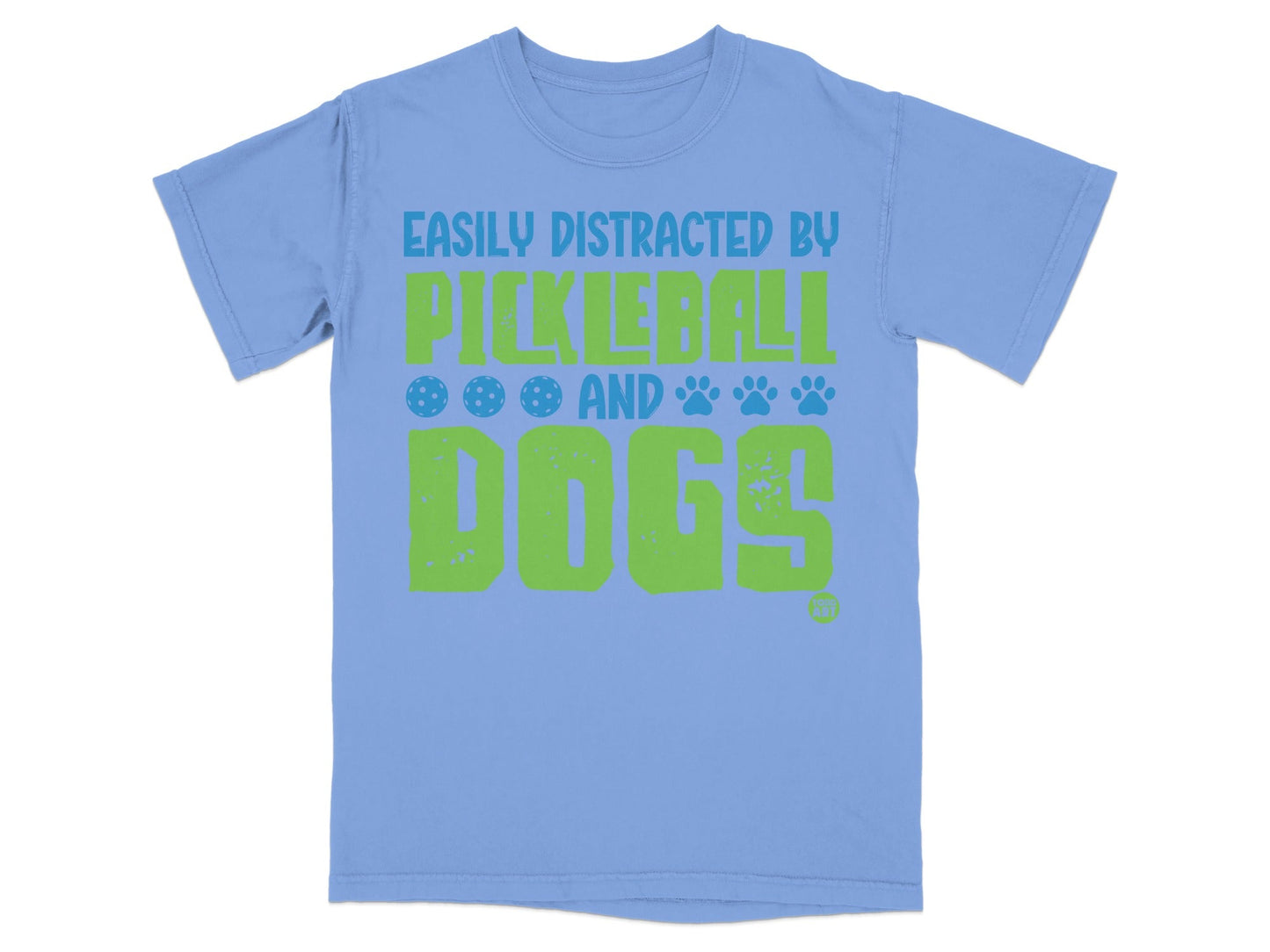 Light blue t-shirt with green text and pickleball/paw print graphics.