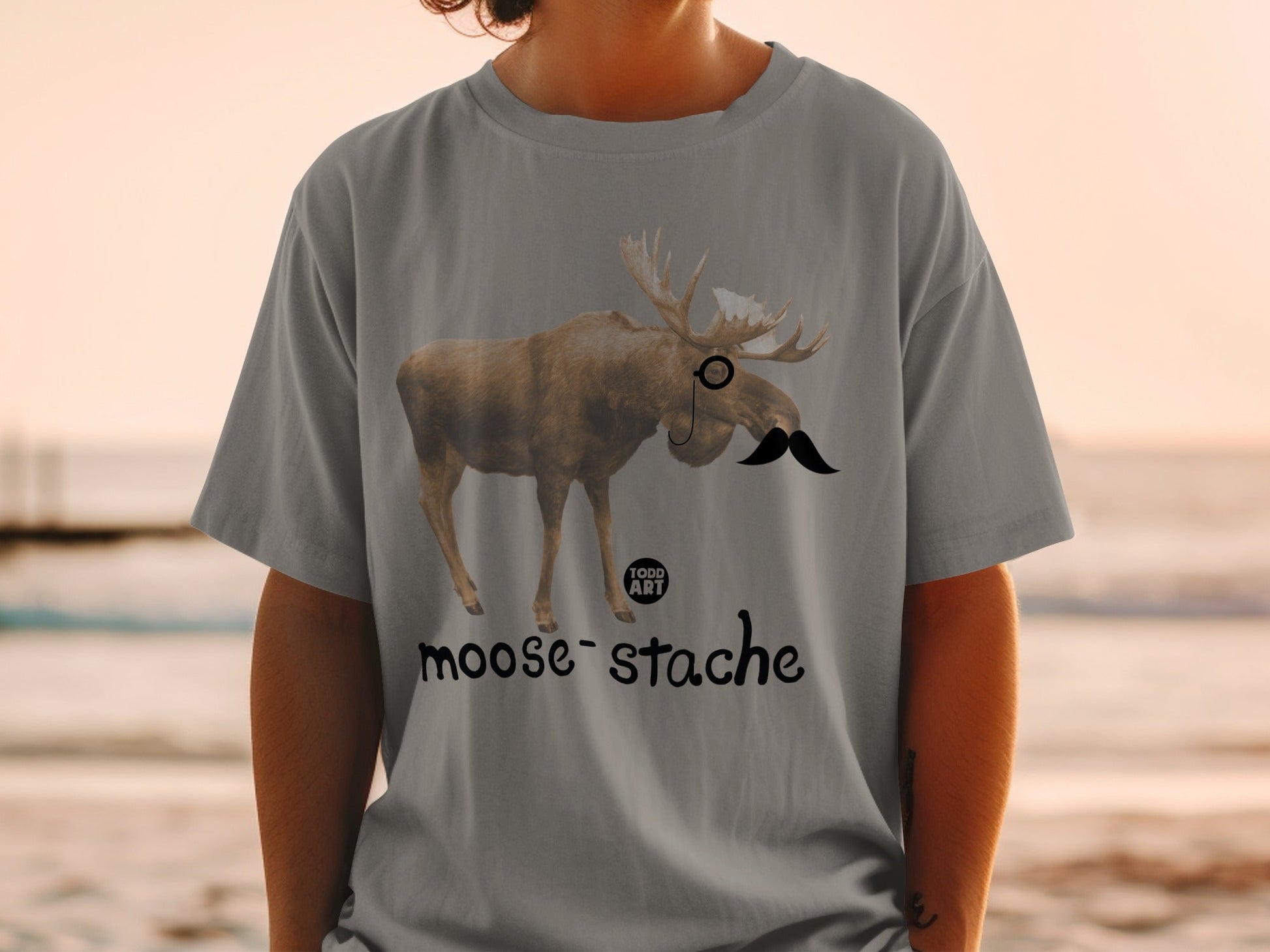 Moose wearing a monocle and mustache, with "moose-stache" text.