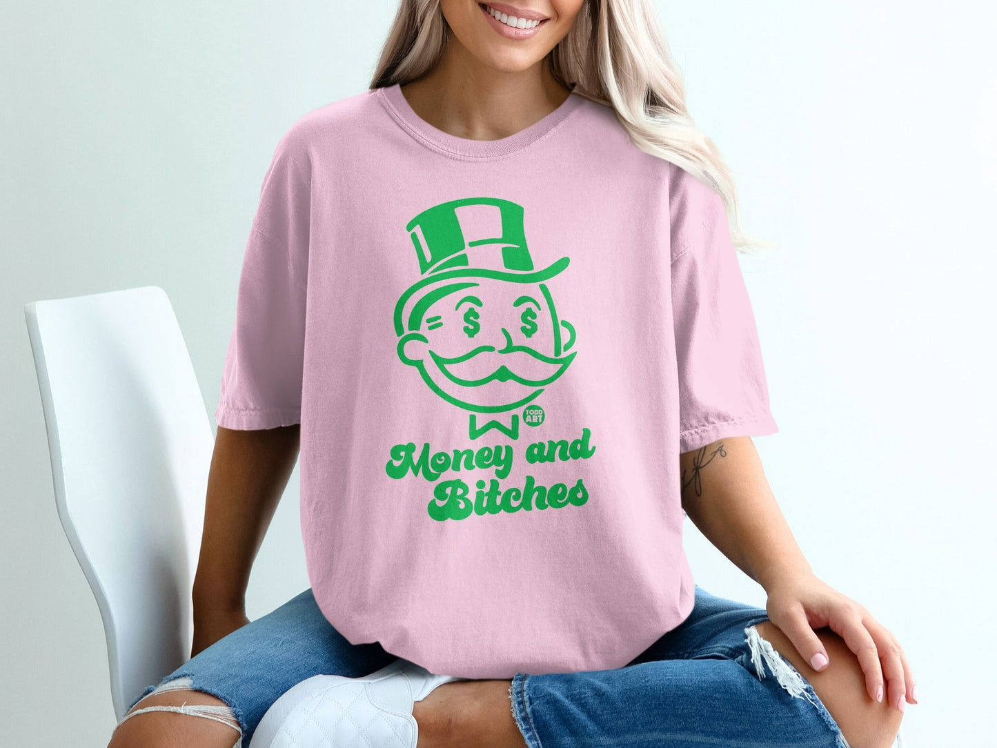 Pink t-shirt with green "Money and Bitches" text and top hat man graphic.