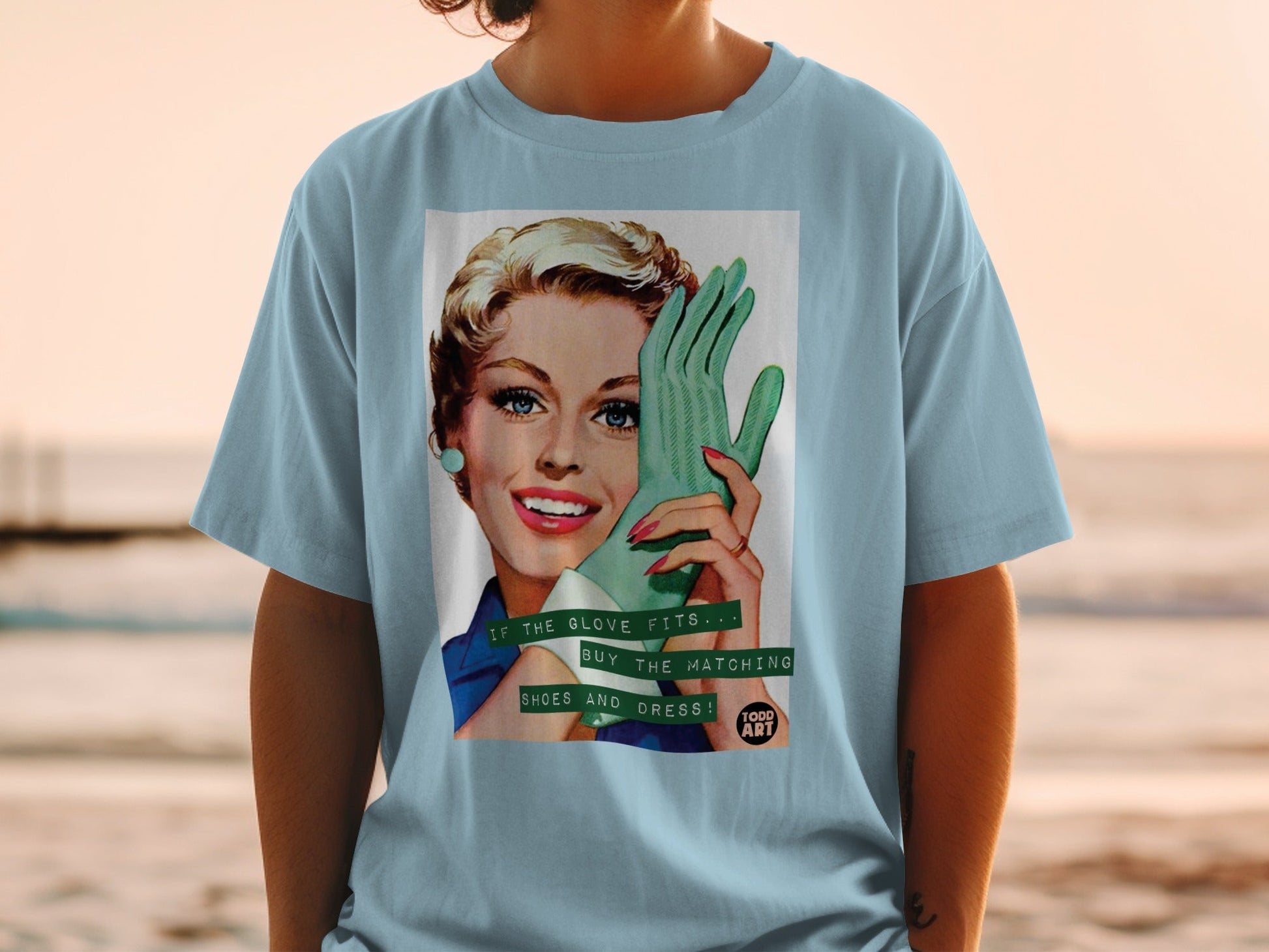 Vintage graphic t-shirt with woman wearing green glove, text "IF THE GLOVE FITS... BUY THE MATCHING SHOES AND DRESS! TODD ART".