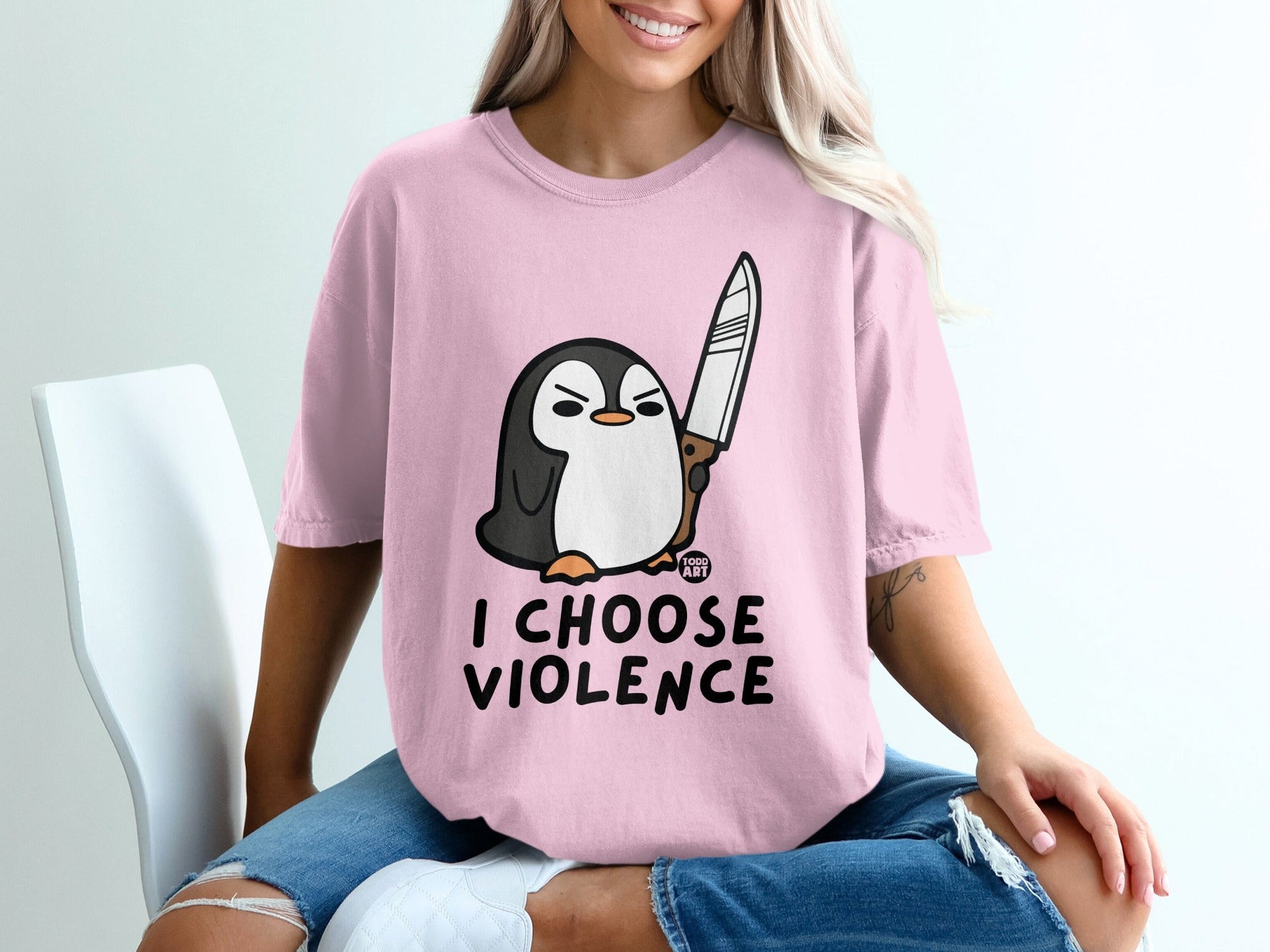 Pink t-shirt with cartoon penguin holding a knife and text "I CHOOSE VIOLENCE".