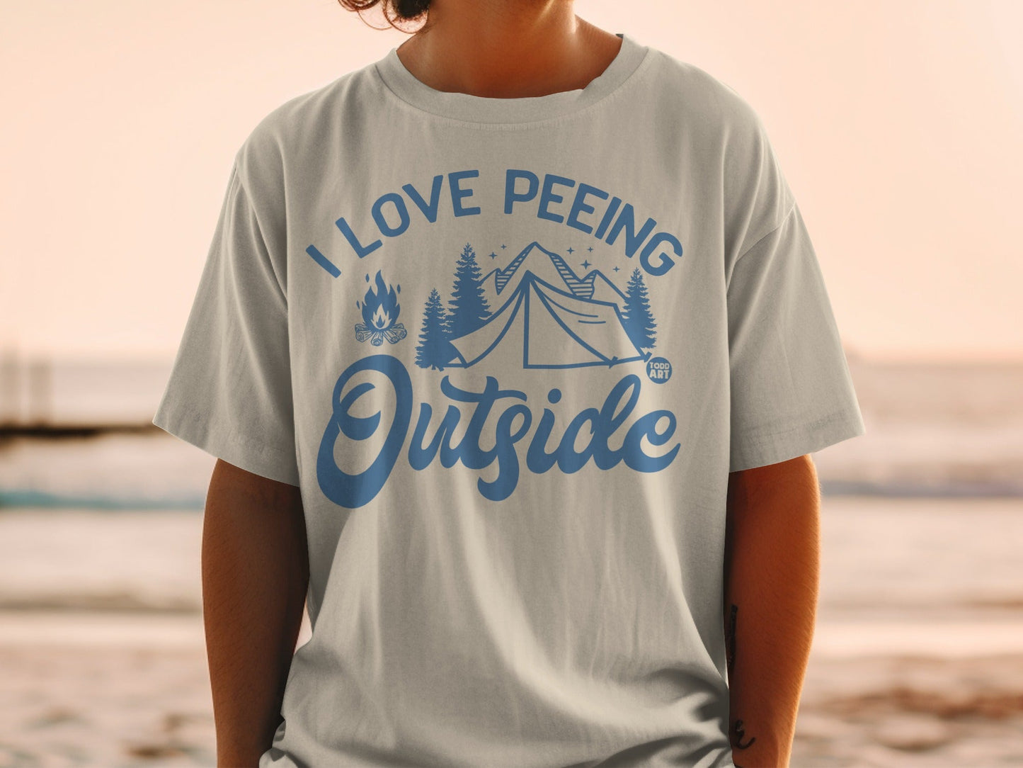 T-shirt with tent, trees, and fire graphic with "I love peeing outside" text.