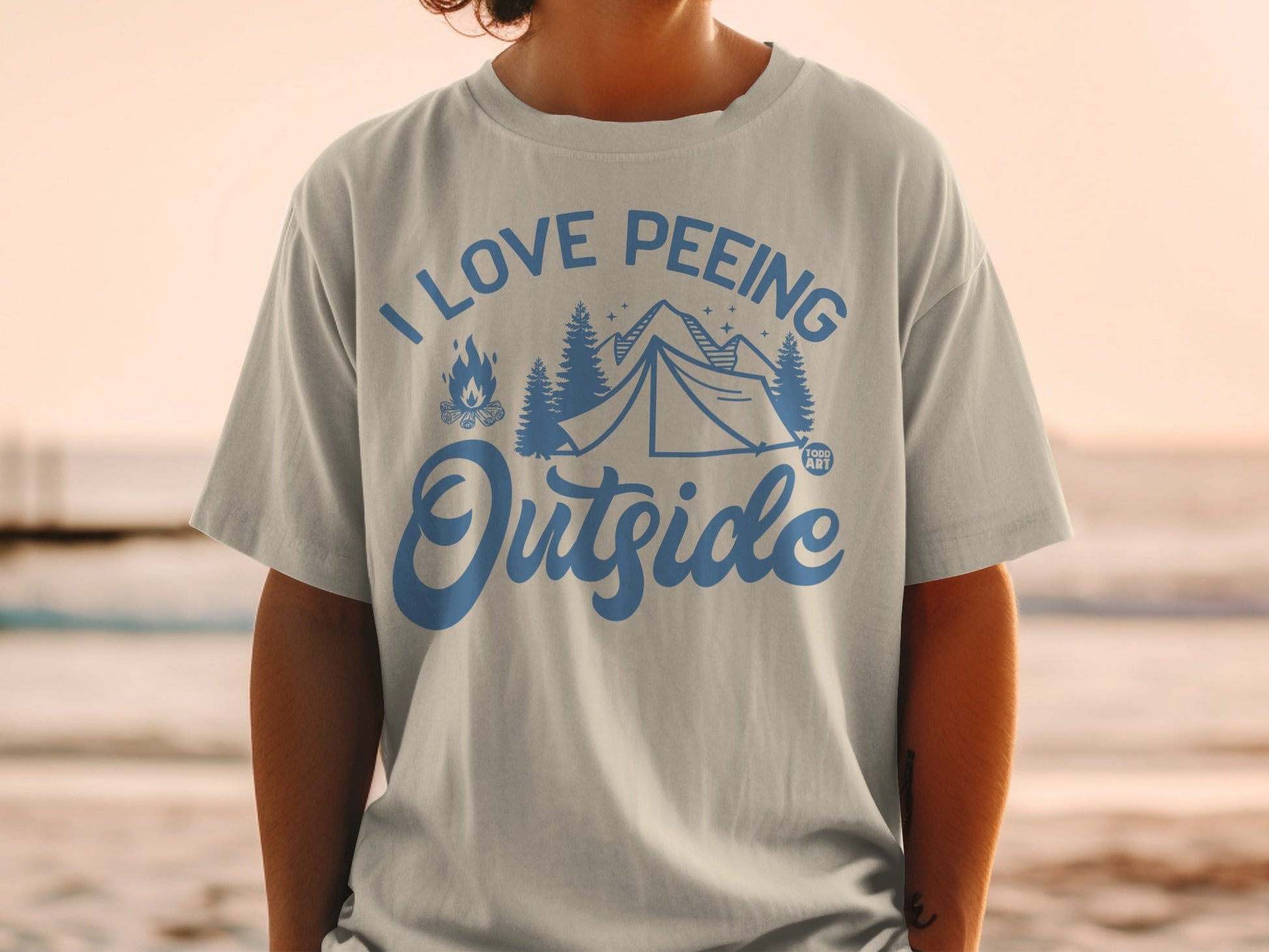 T-shirt with tent, trees, and fire graphic with "I love peeing outside" text.
