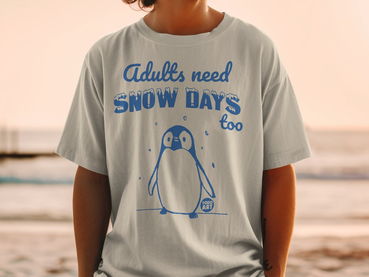 T-shirt with penguin graphic and "Adults need Snow Days too" text.