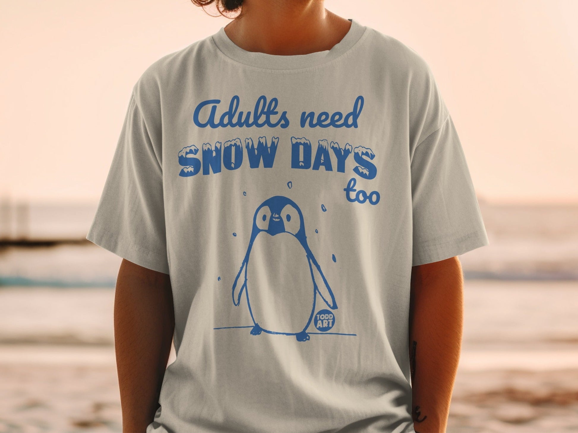 T-shirt with penguin graphic and "Adults need Snow Days too" text.