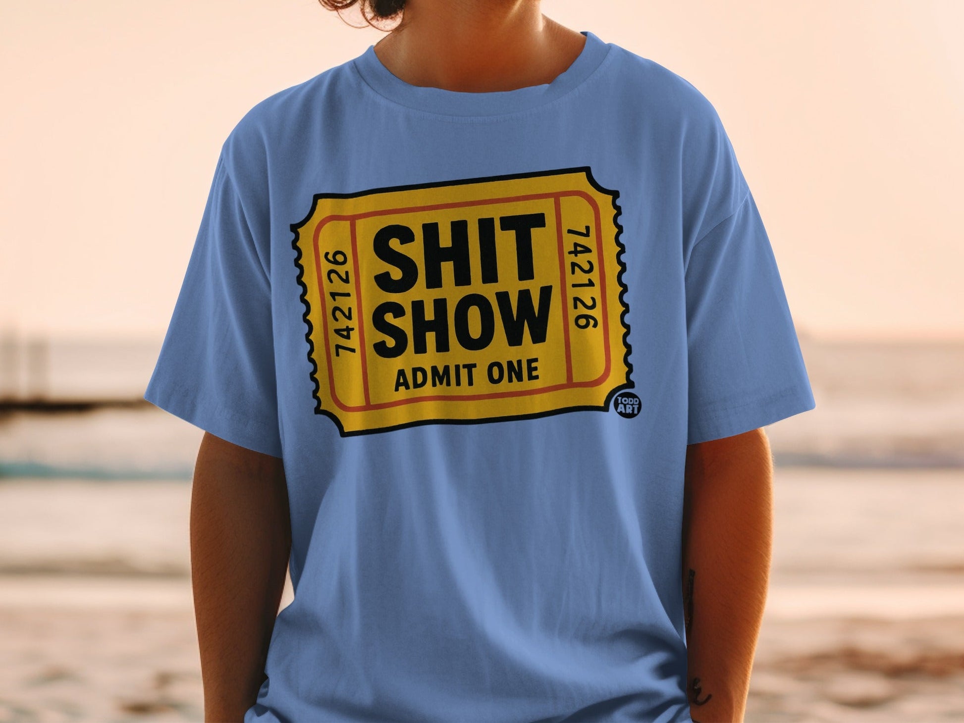 Blue t-shirt with a yellow ticket design reading "SHIT SHOW ADMIT ONE."