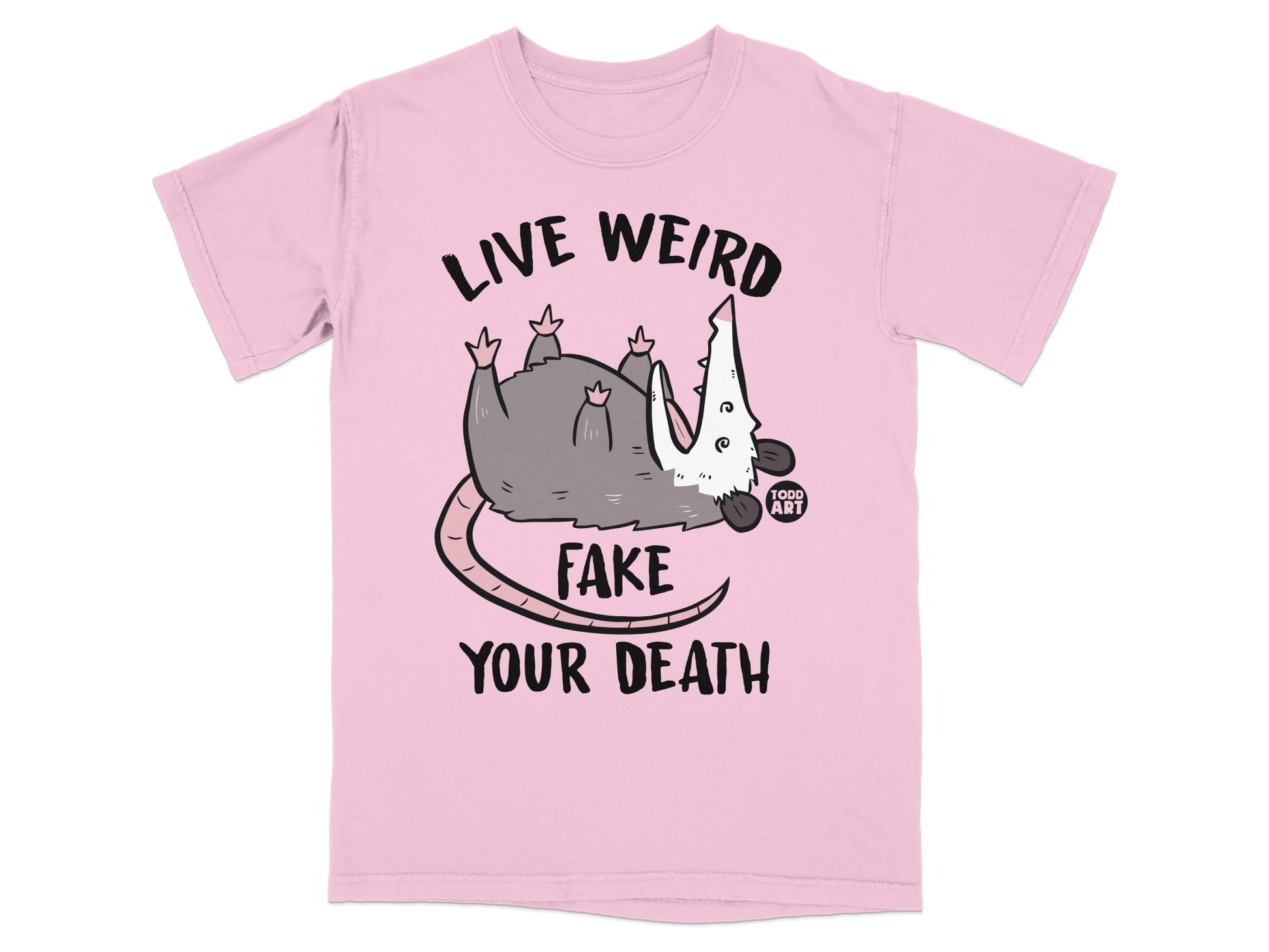 Pink t-shirt with opossum graphic and text "LIVE WEIRD FAKE YOUR DEATH".