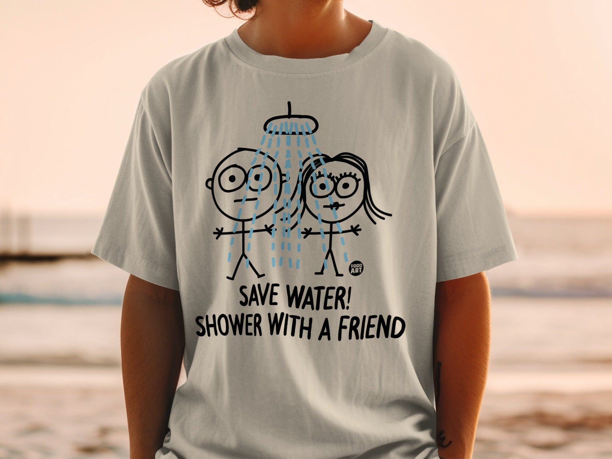White t-shirt with cartoon couple showering, text "SAVE WATER! SHOWER WITH A FRIEND".