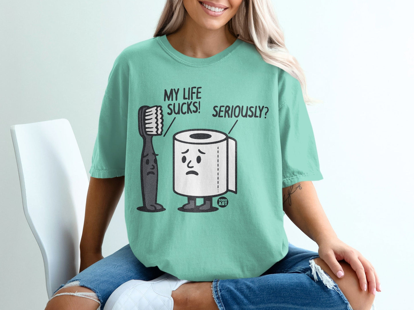 T-shirt with cartoon toothbrush and toilet paper characters saying "MY LIFE SUCKS! SERIOUSLY?".