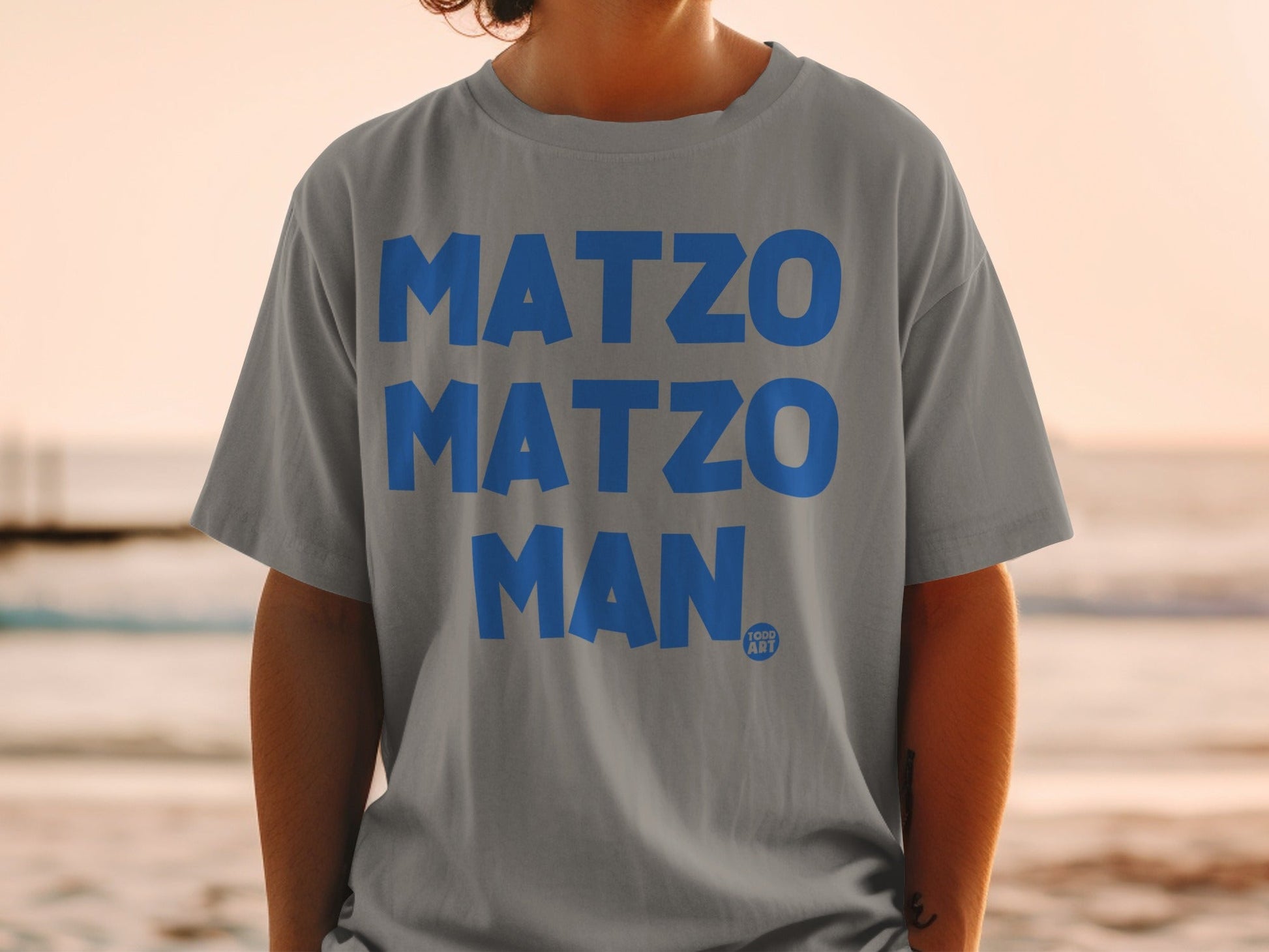 Gray t-shirt with bold blue "MATZO MATZO MAN" text and a small TOOC ART logo.