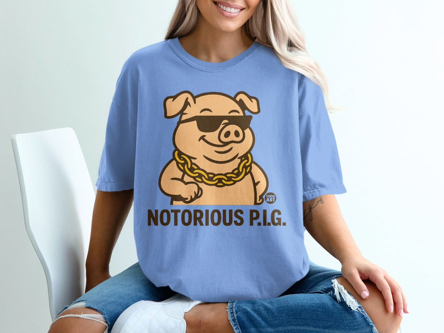Blue t-shirt with cartoon pig wearing sunglasses and gold chain, text "NOTORIOUS P.I.G."