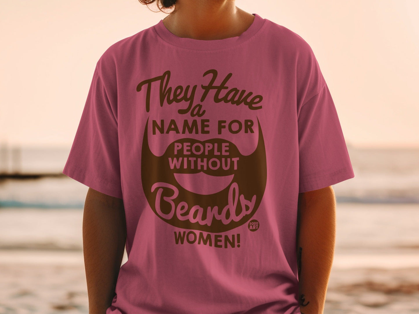 Pink t-shirt with "They have a name for people without beards WOMEN!" text.