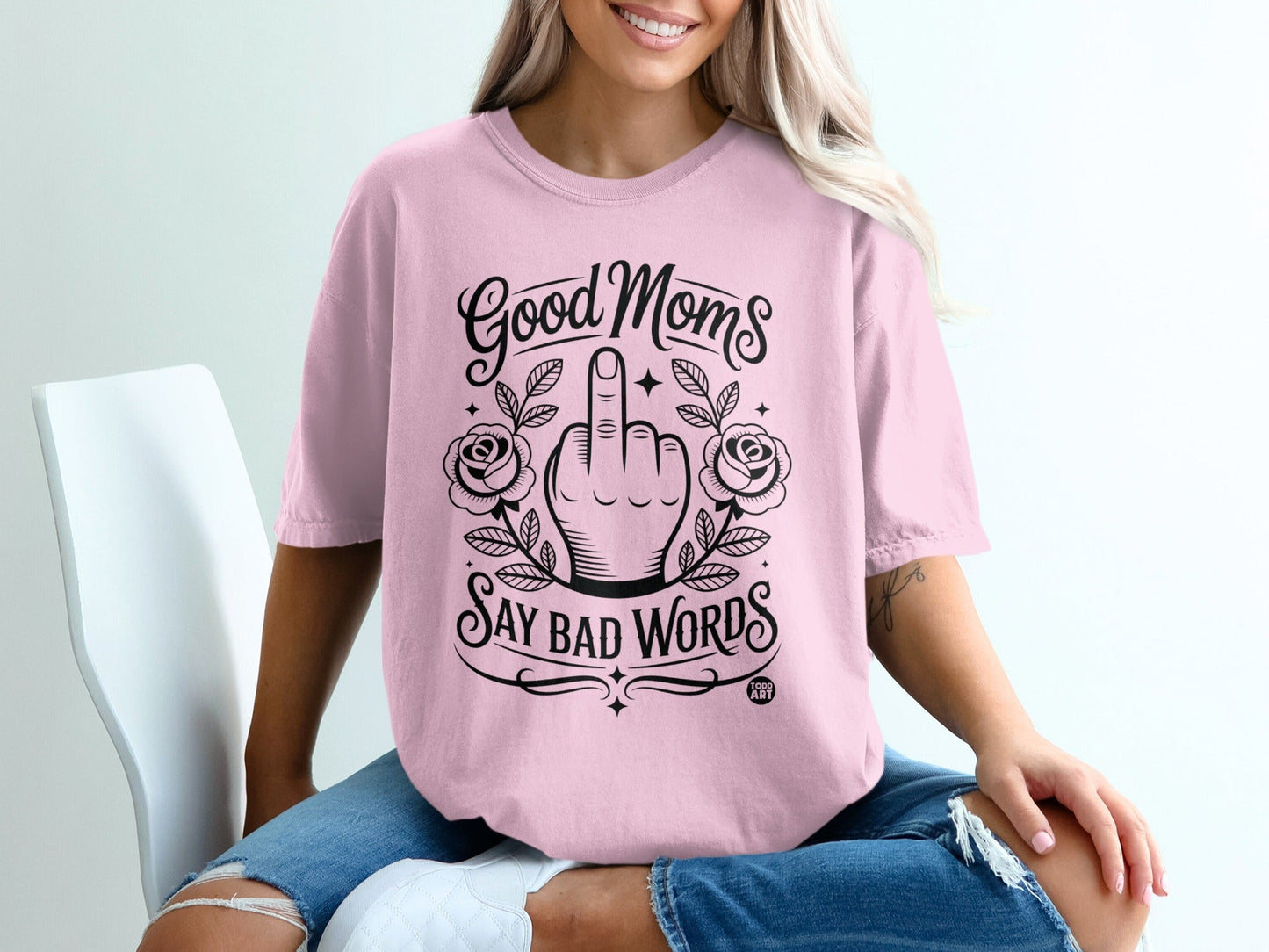Pink t-shirt with "Good Moms Say Bad Words" text and floral graphic.
