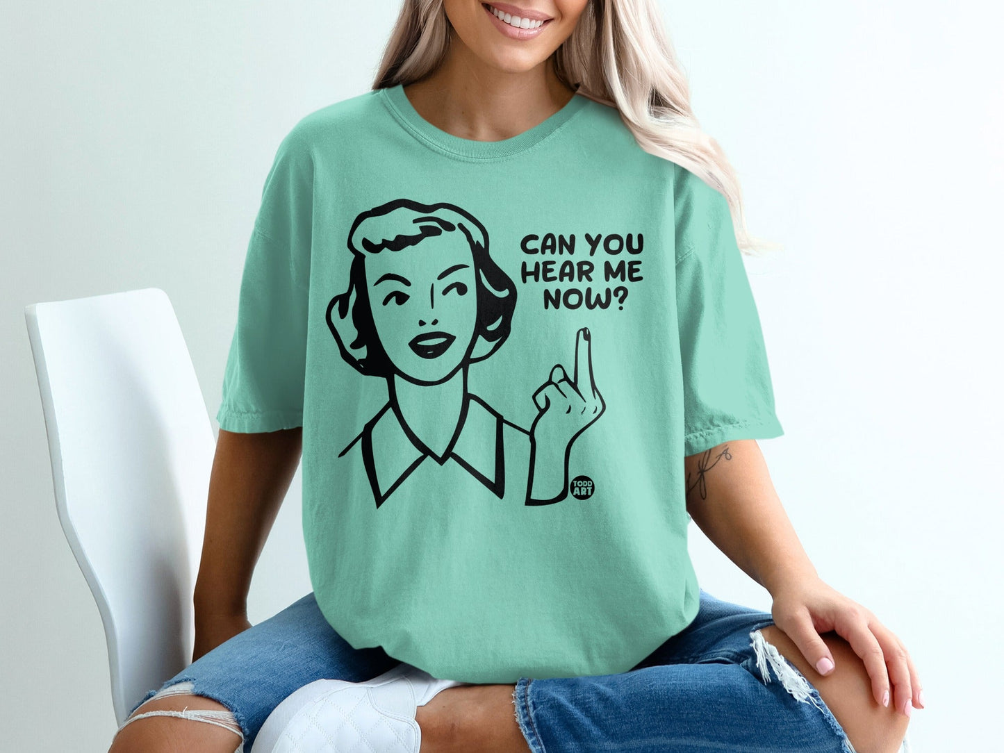 Mint t-shirt with black line drawing of woman asking "Can you hear me now?".