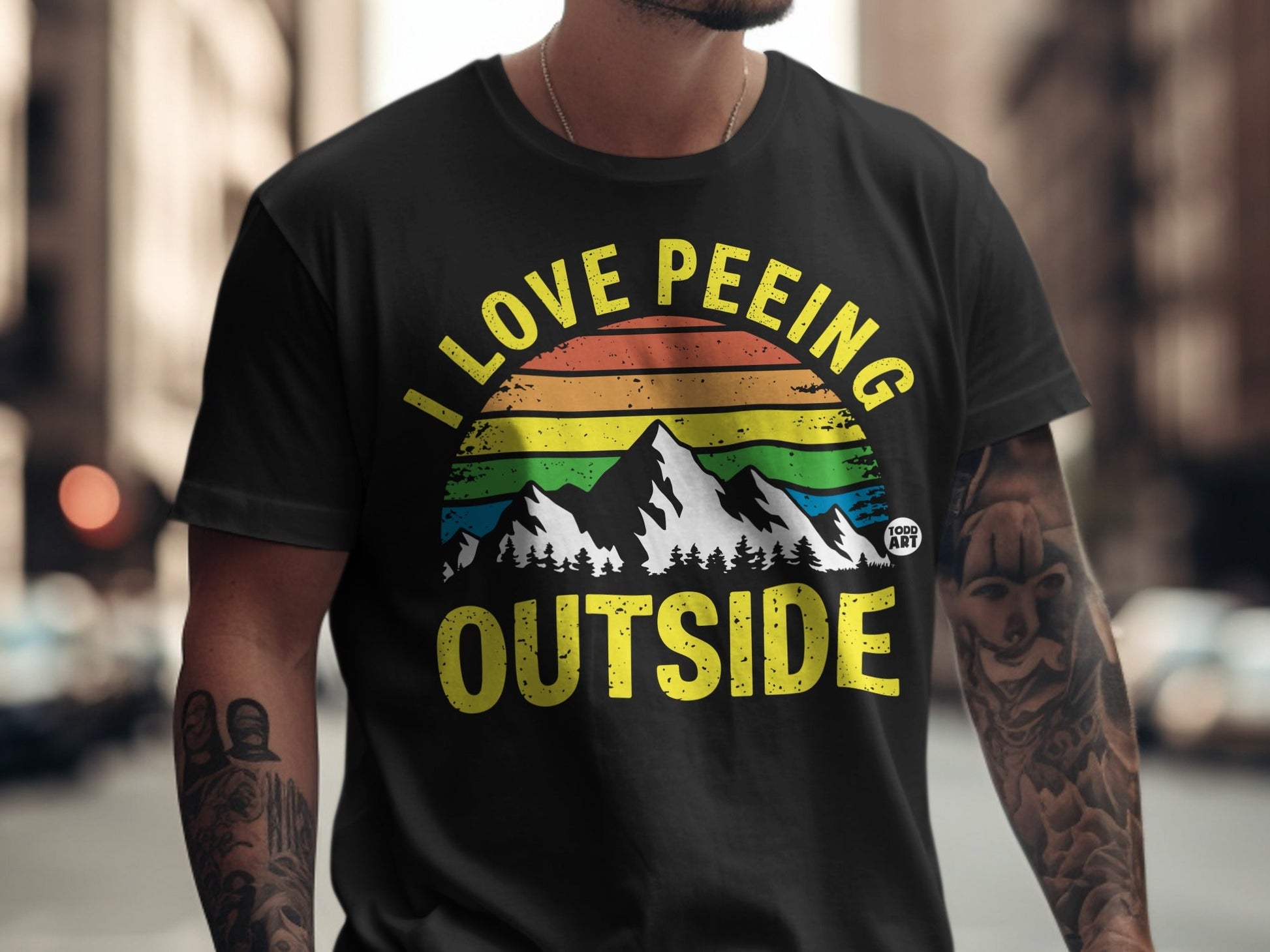 Black t-shirt with rainbow mountains and "I love peeing outside" text.