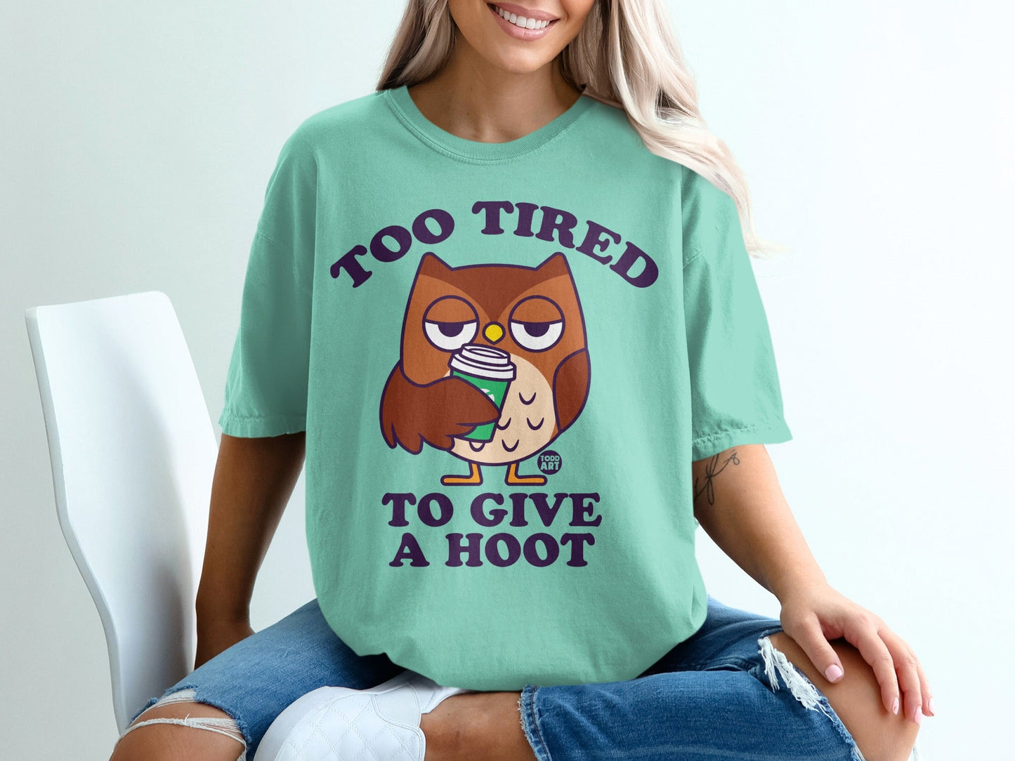 T-shirt with cartoon owl saying "Too tired to give a hoot" holding coffee cup.