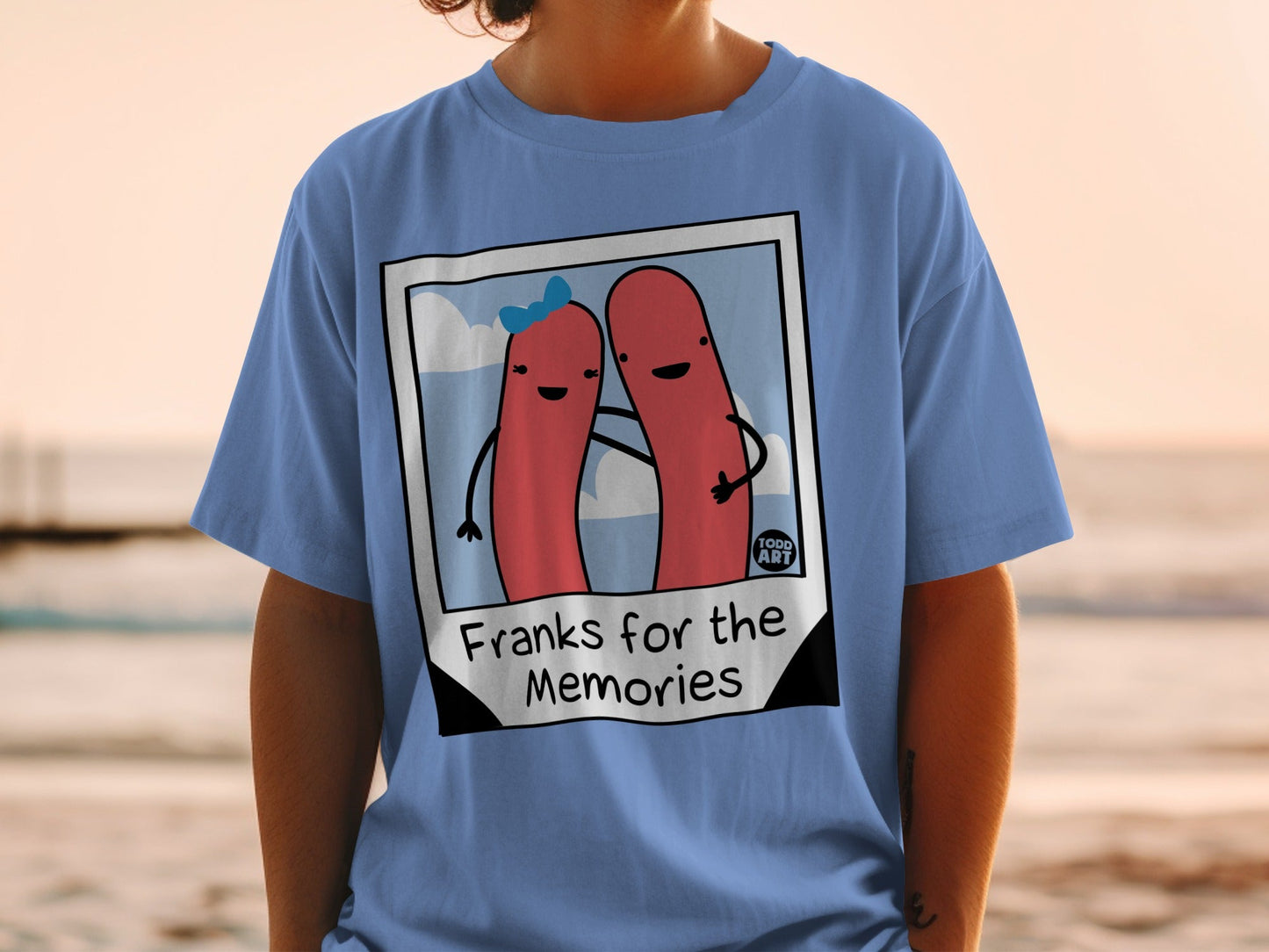 Blue t-shirt with cartoon hot dogs and "Franks for the Memories" text.
