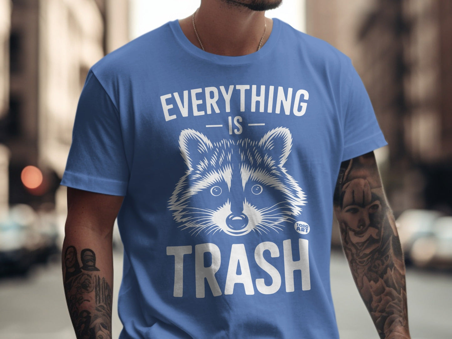 Blue t-shirt with raccoon graphic and "EVERYTHING IS TRASH" text.