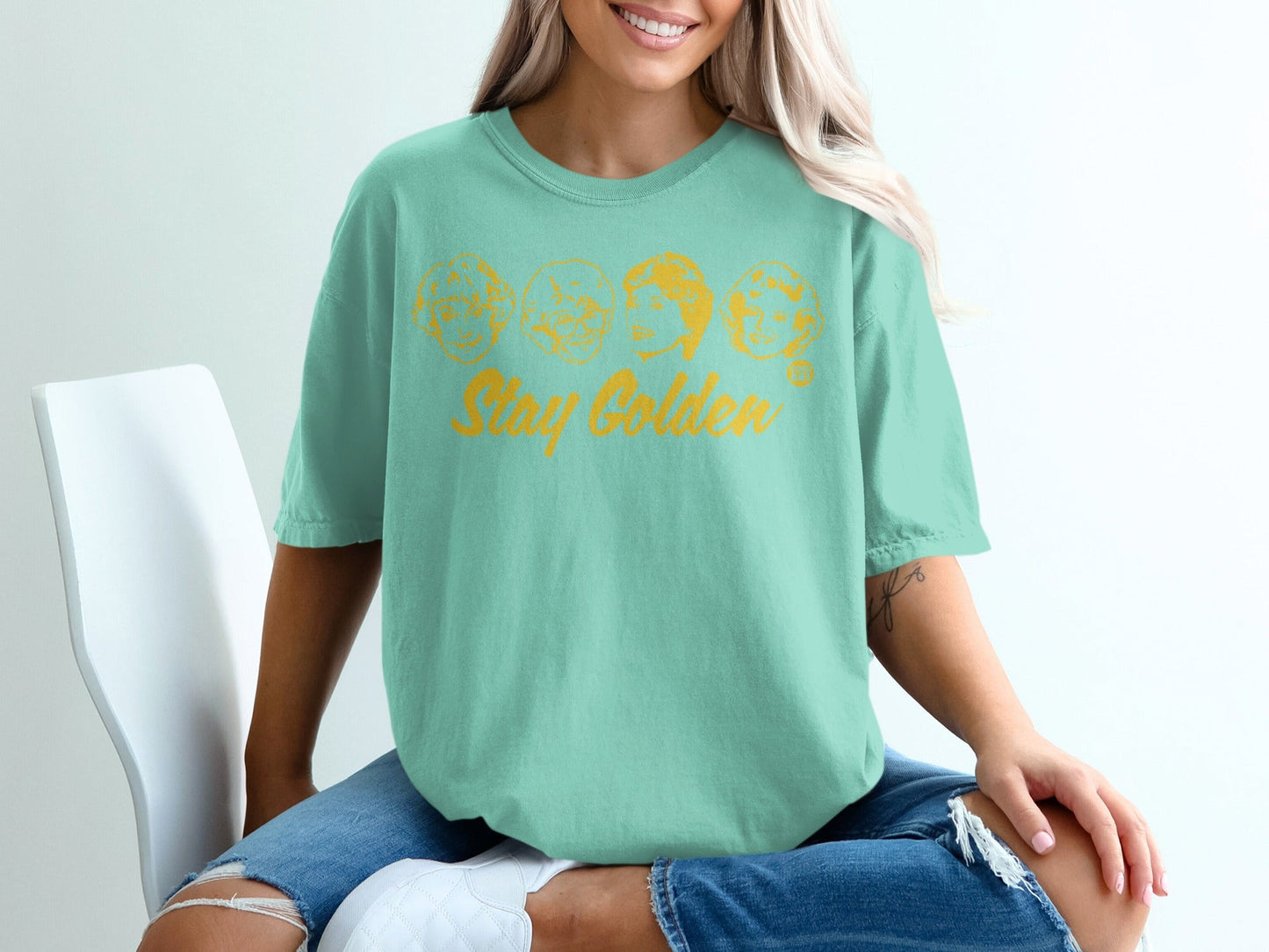 Mint t-shirt with "Stay Golden" and four character faces printed on front.