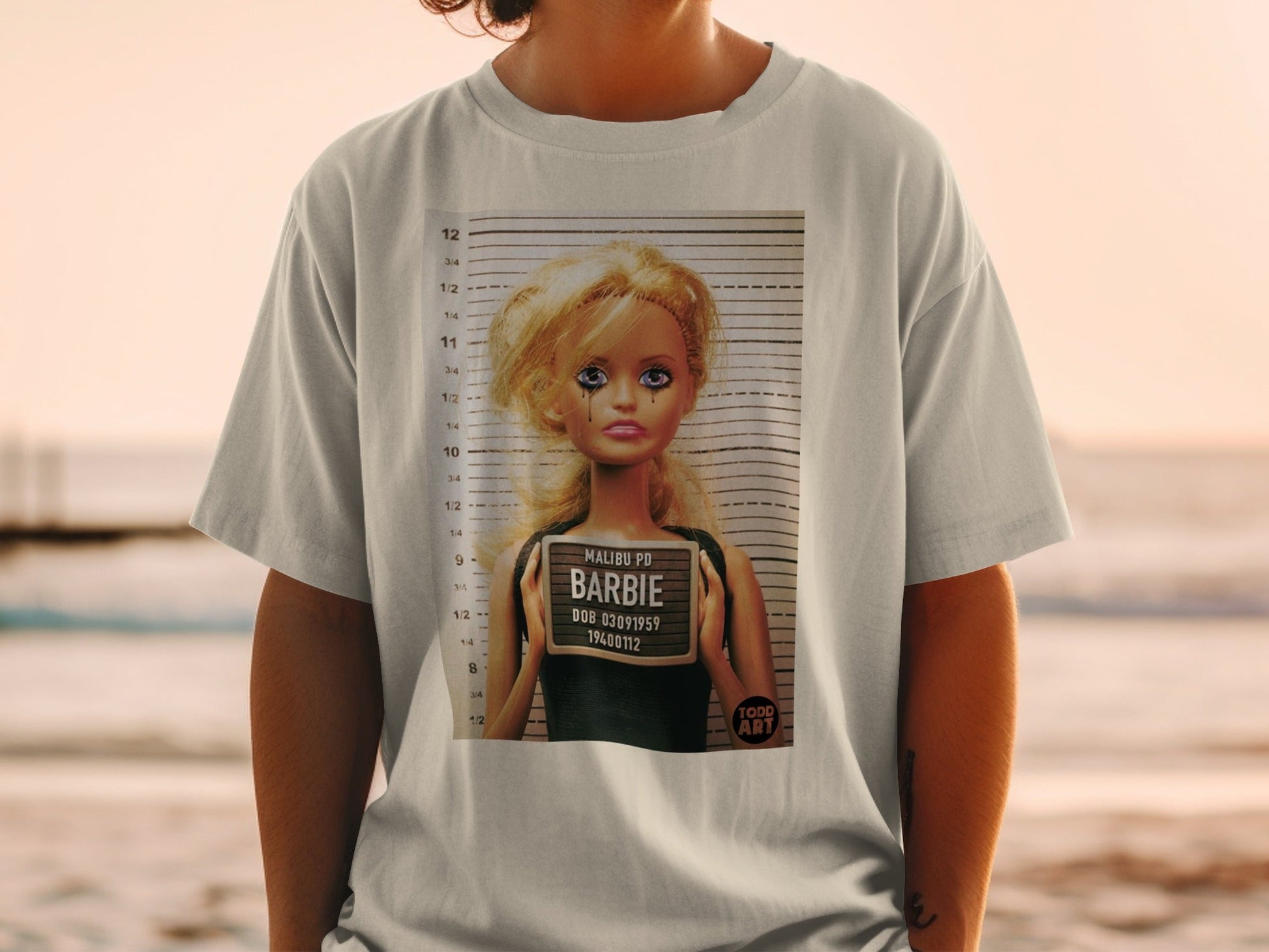 Barbie's mugshot on a t-shirt, featuring "Malibu PD" and DOB 03091959.