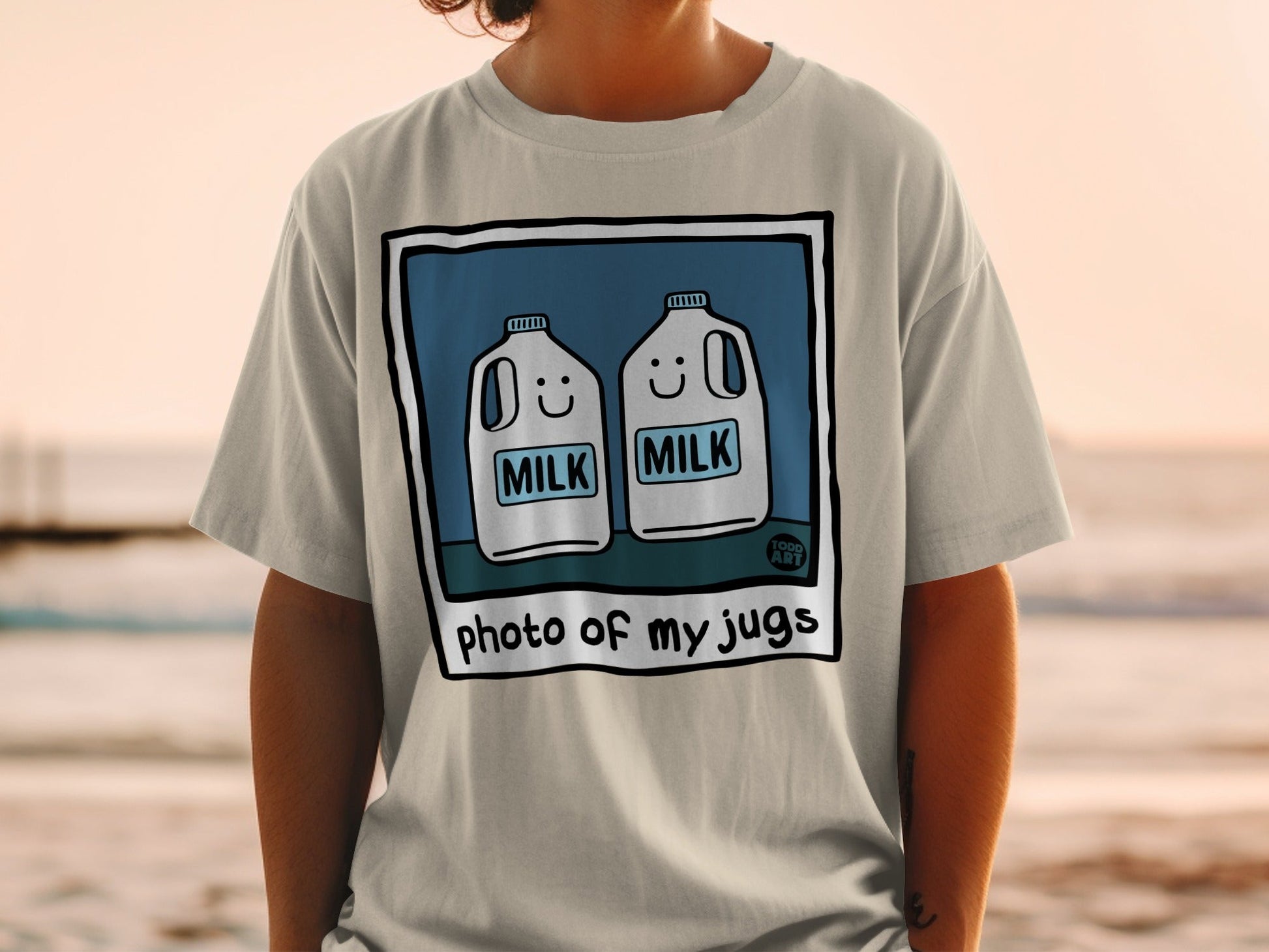 T-shirt graphic with two smiling milk jugs and text "photo of my jugs".