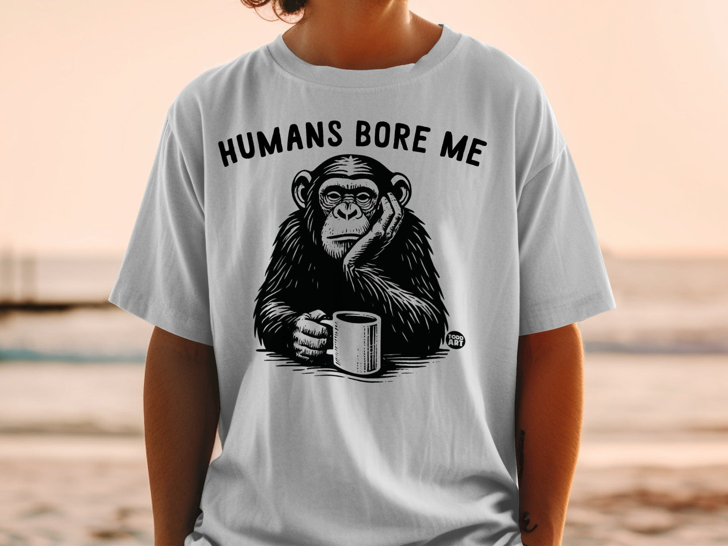 Chimpanzee on t-shirt holding coffee cup, text "HUMANS BORE ME".