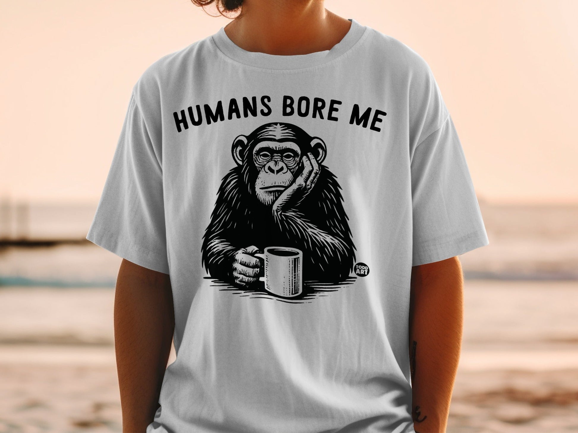Chimpanzee on t-shirt holding coffee cup, text "HUMANS BORE ME".