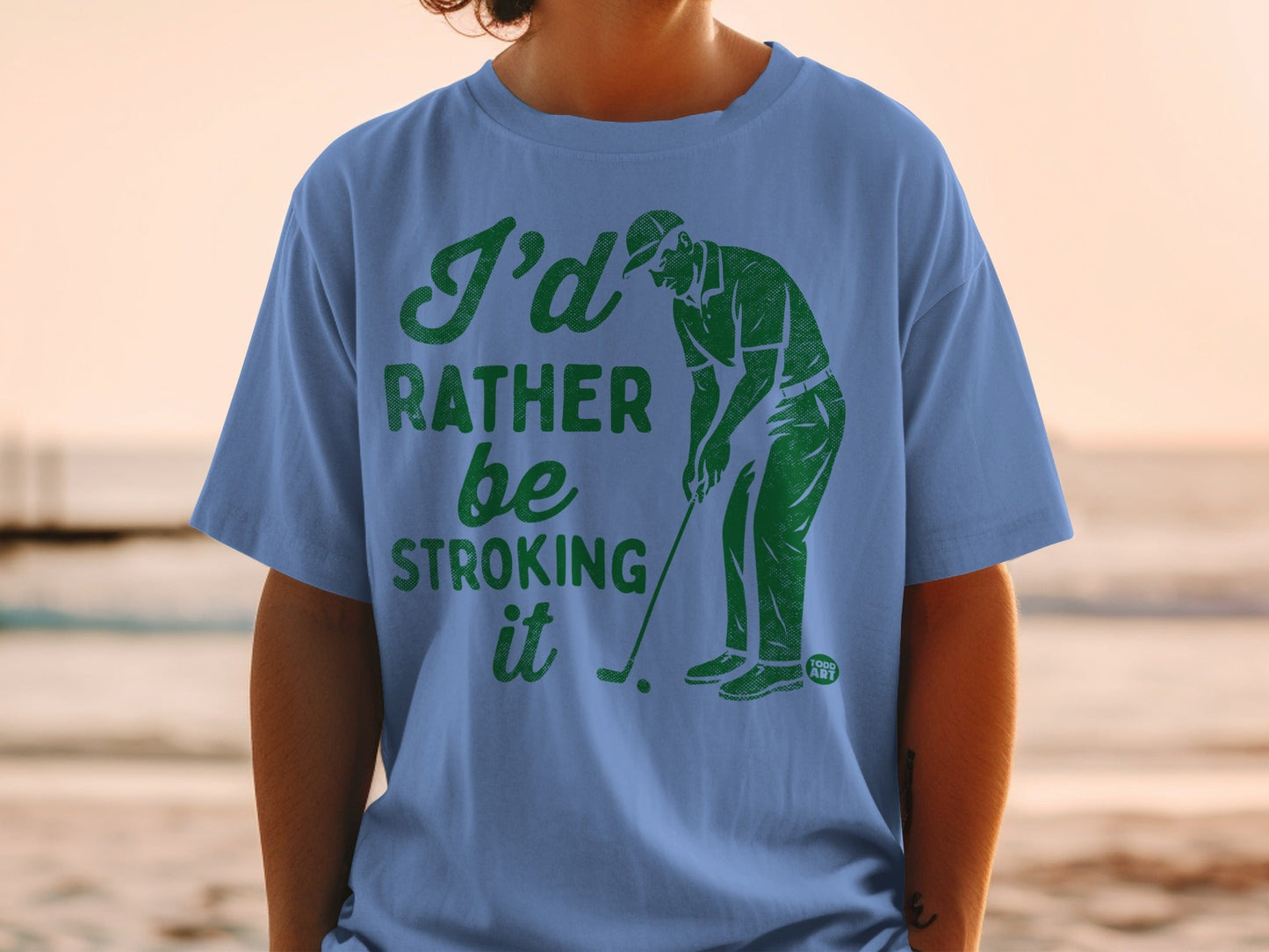 Blue t-shirt with green text "I'd Rather Be Stroking It" and golfer graphic.