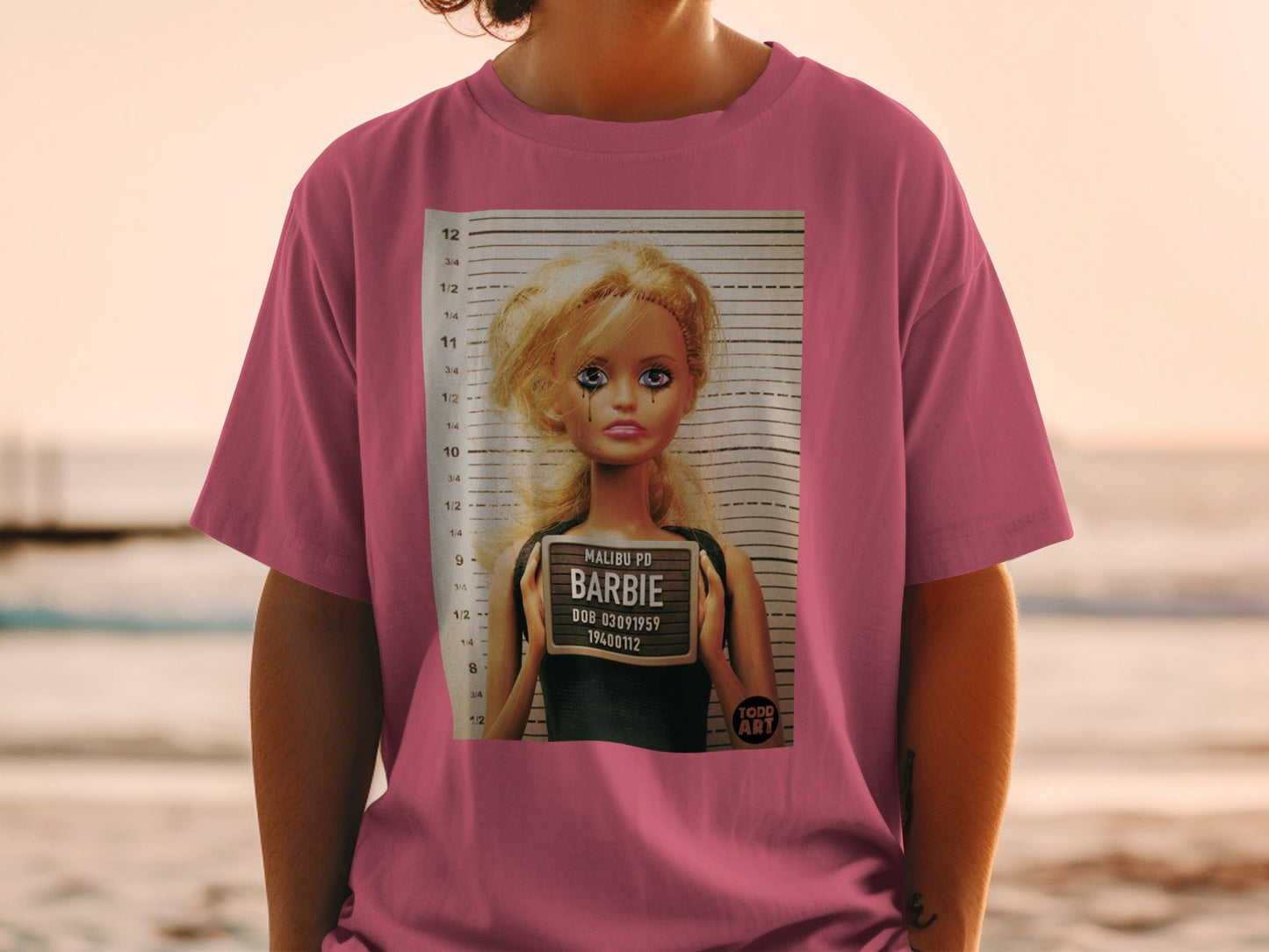 Barbie mugshot with "Malibu PD" and "DOB 03091959" on sign.