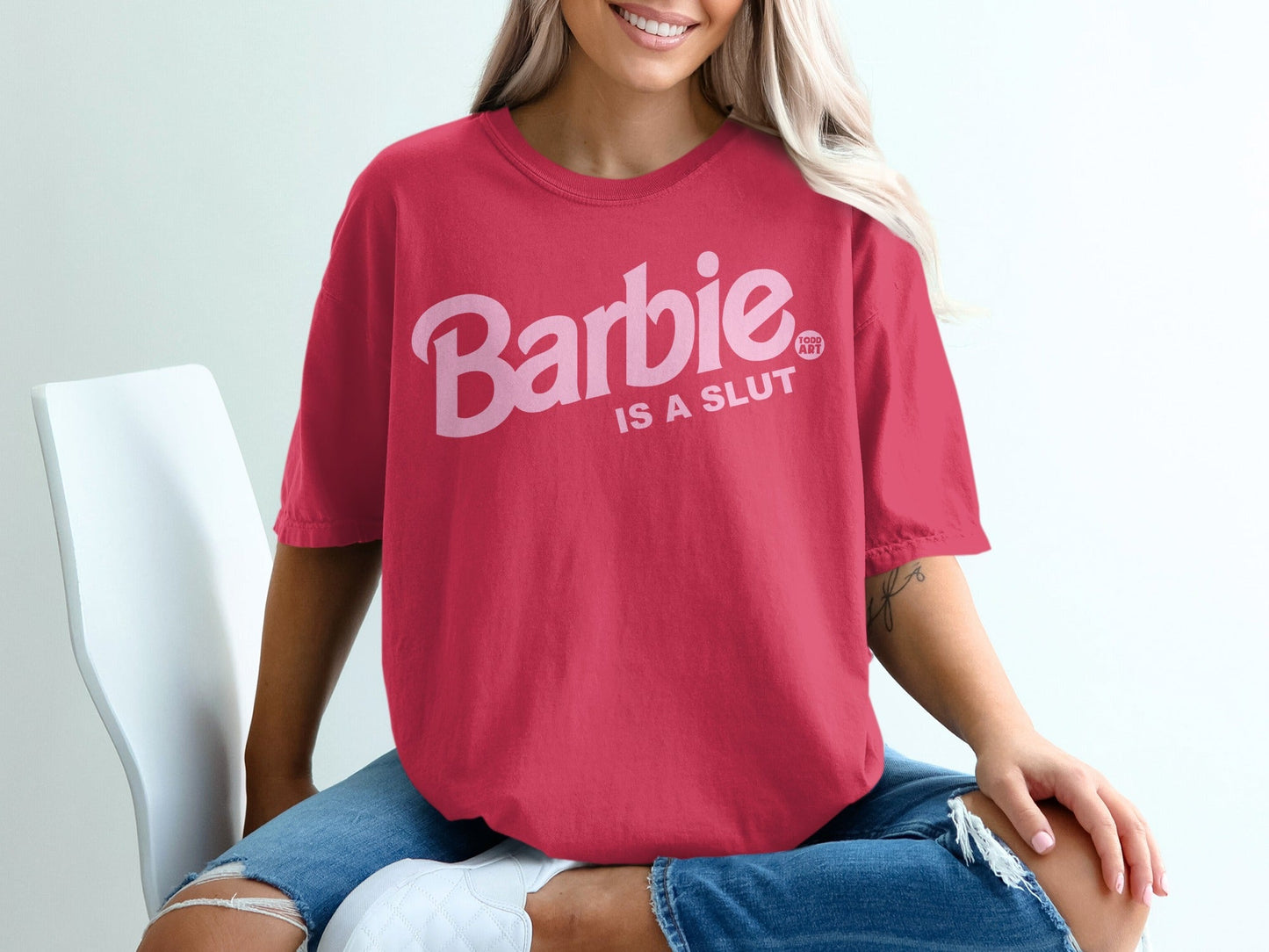 Pink t-shirt with "Barbie is a SLUT" text in bold pink letters.