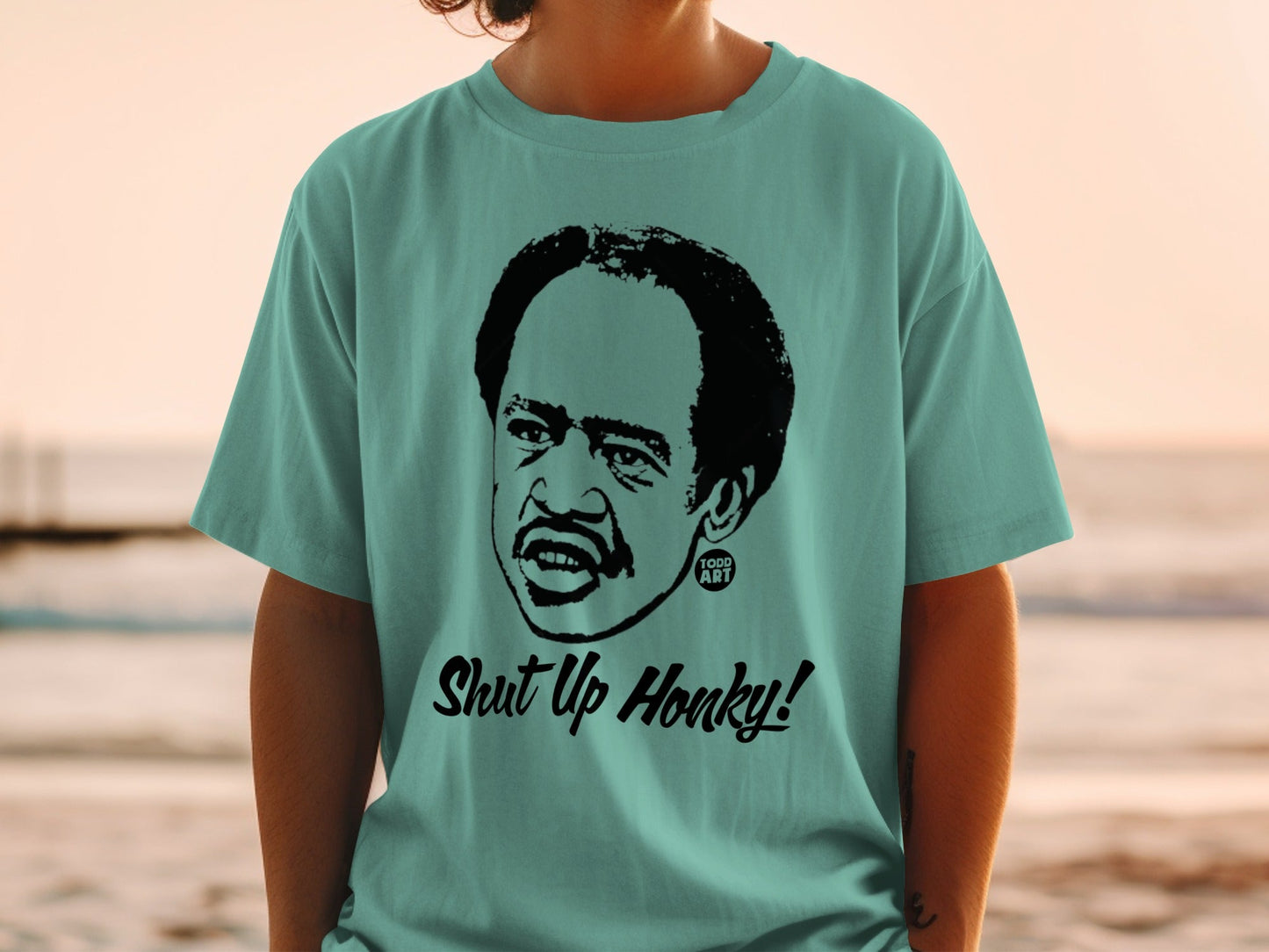 Teal t-shirt with a black graphic of Richard Pryor and "Shut Up Honky!" text.