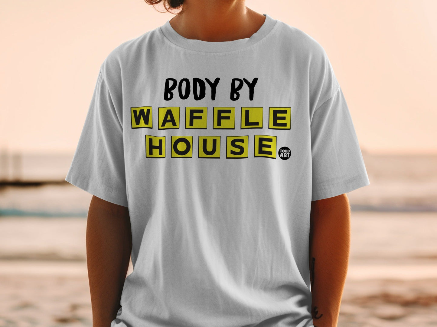 White t-shirt with "BODY BY WAFFLE HOUSE" in yellow and black block letters.