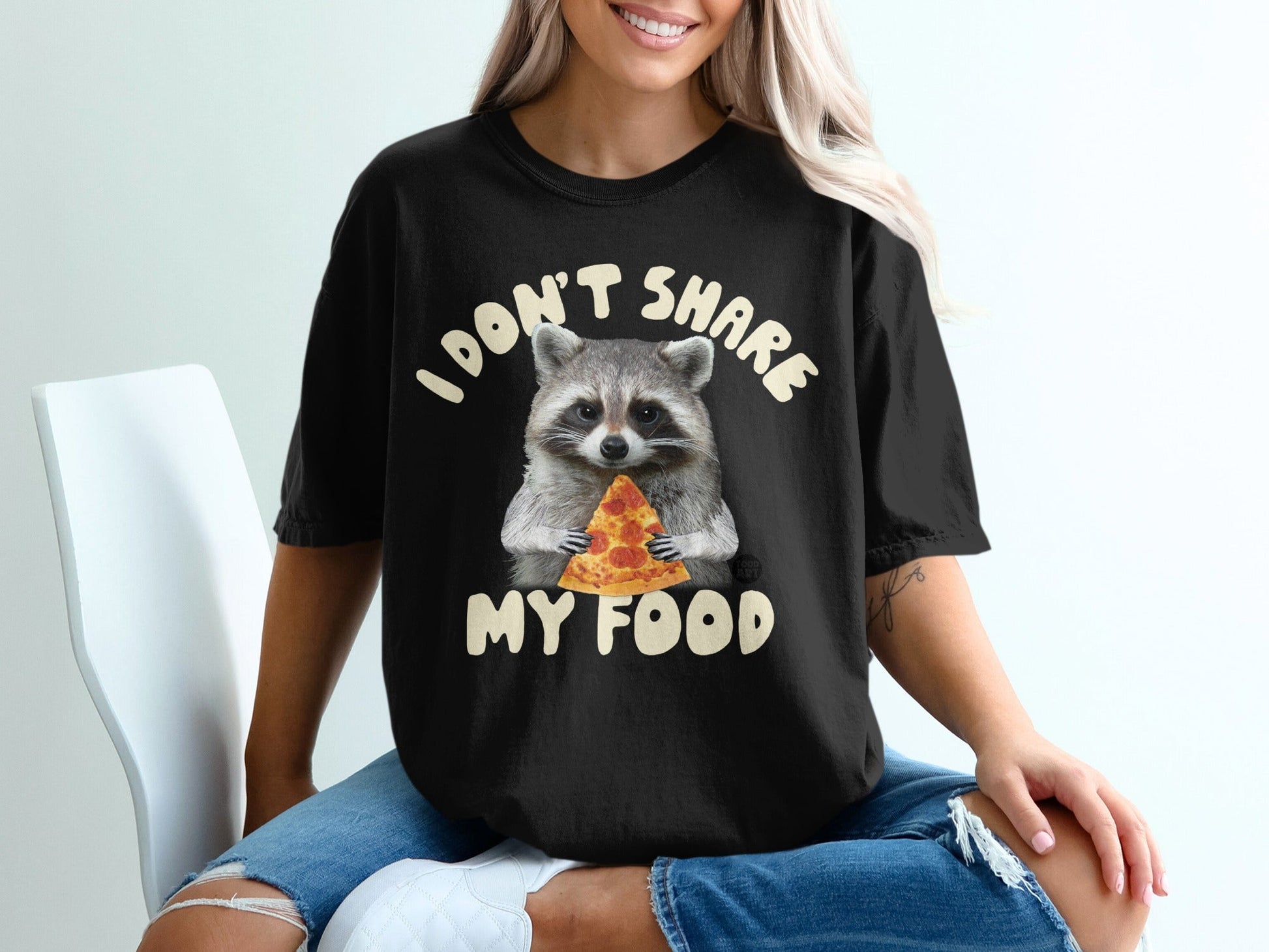 Black t-shirt with a raccoon holding a slice of pizza and text "I DON'T SHARE MY FOOD".