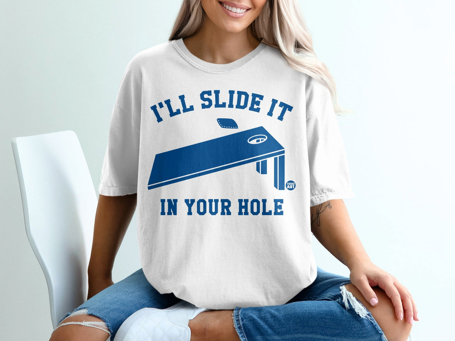 White t-shirt with "I'll slide it in your hole" text and cornhole board graphic.