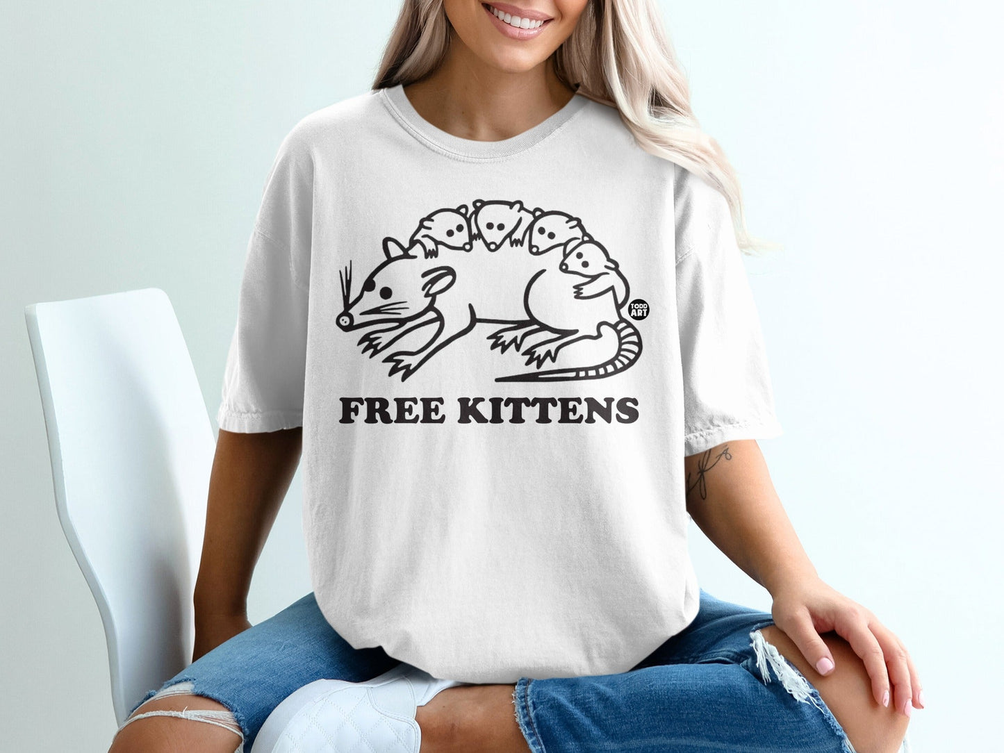White t-shirt with graphic of a mother rat and kittens, text "FREE KITTENS".