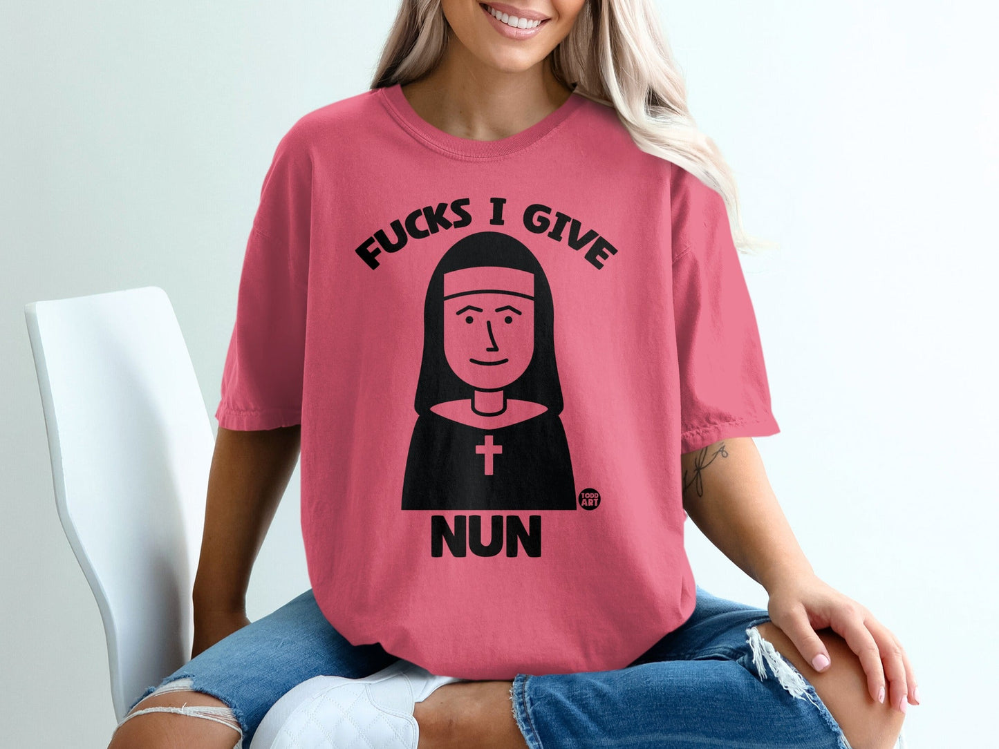 Pink t-shirt with nun graphic and "Fucks I Give Nun" text.